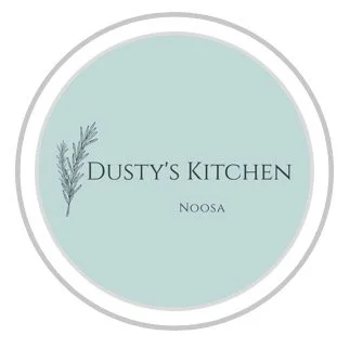 Logo for Dusty's Kitchen in Noosa with a light blue background and a small sprig of greenery.