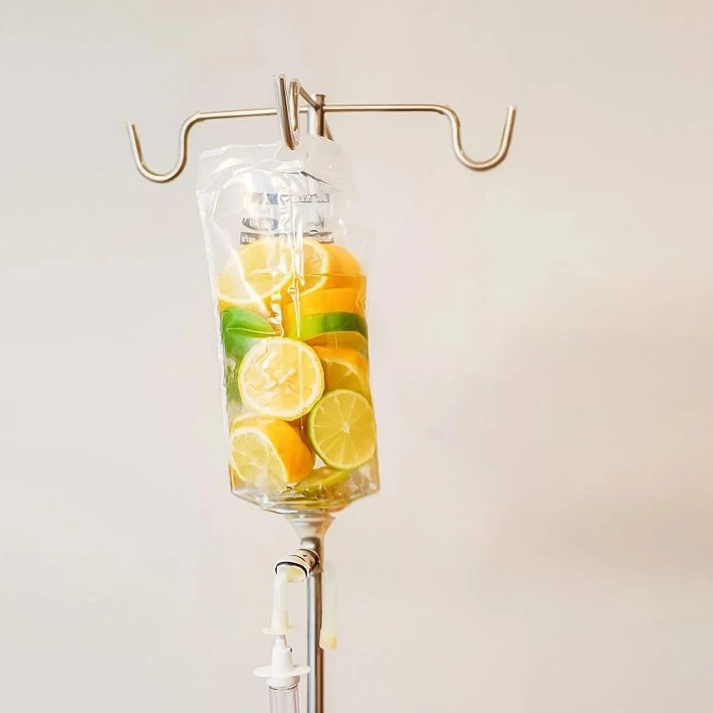 Infusion bag hanging from an IV pole filled with sliced citrus fruits like lemons, limes, and oranges.