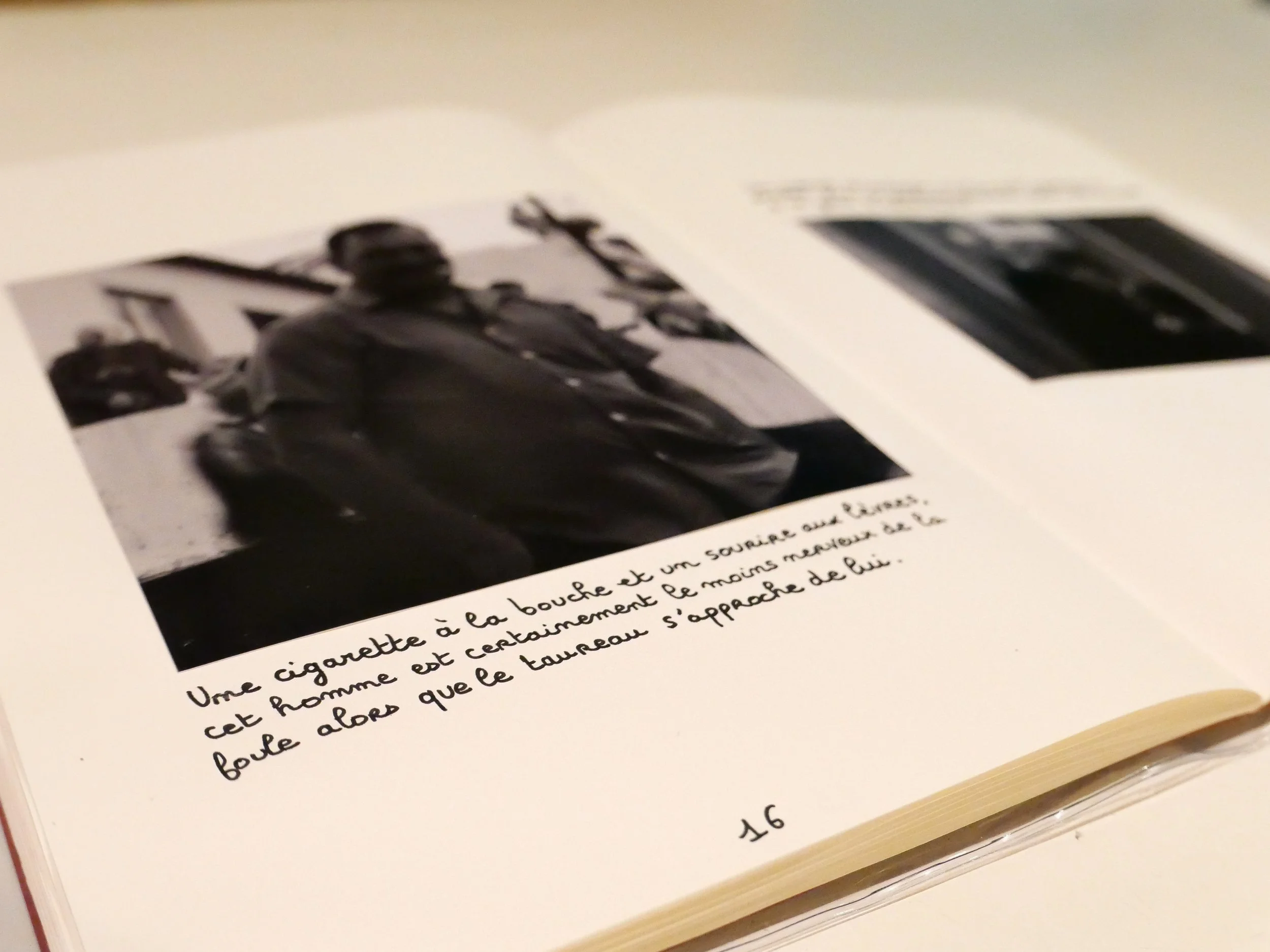 Une photo noir et blanc de plusieurs hommes, dont un à l'avant avec une cigarette et un sourire, dans un environnement extérieur.