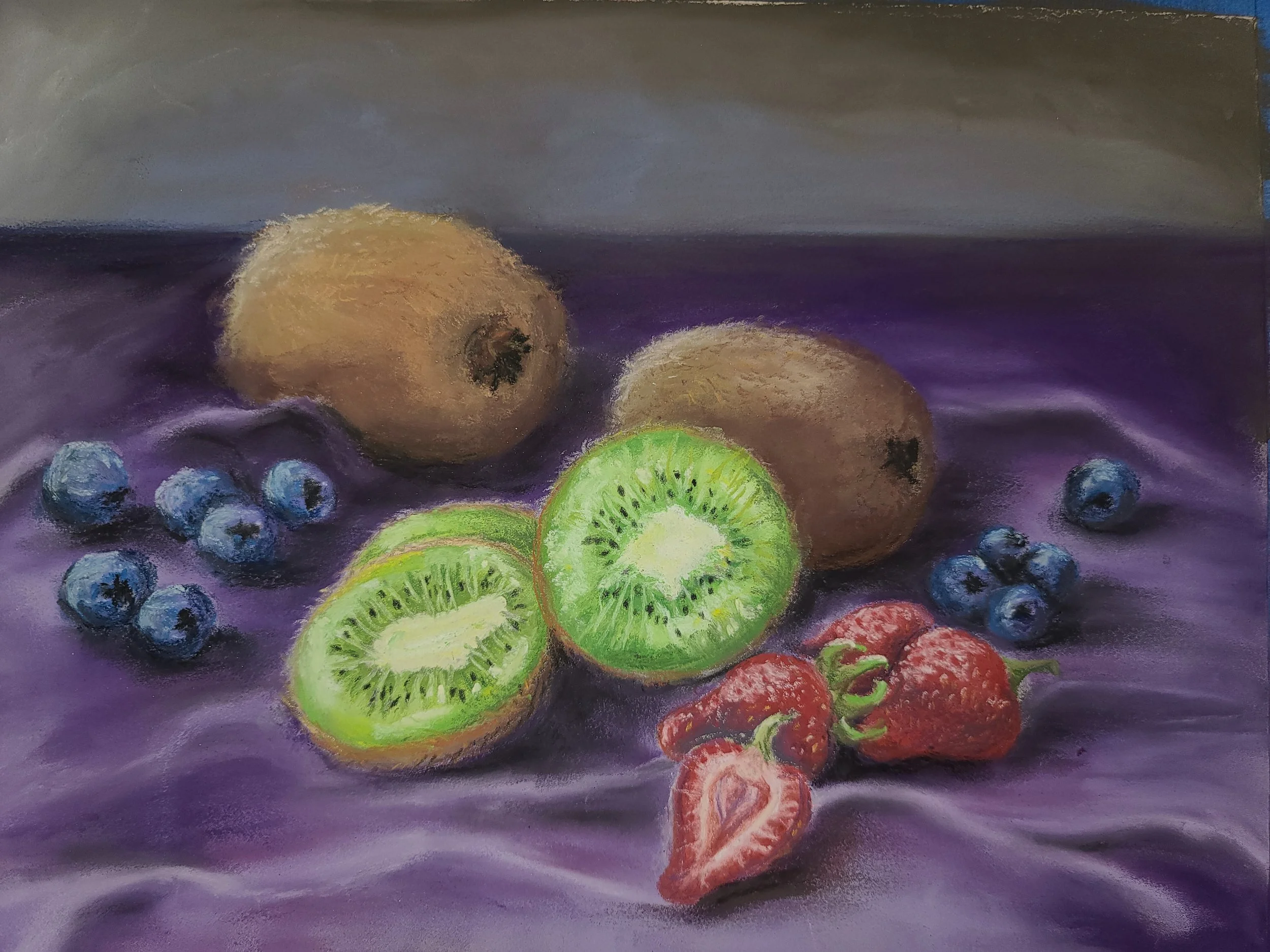 Pastel drawing of kiwis, strawberries, and blueberries on purple fabric.