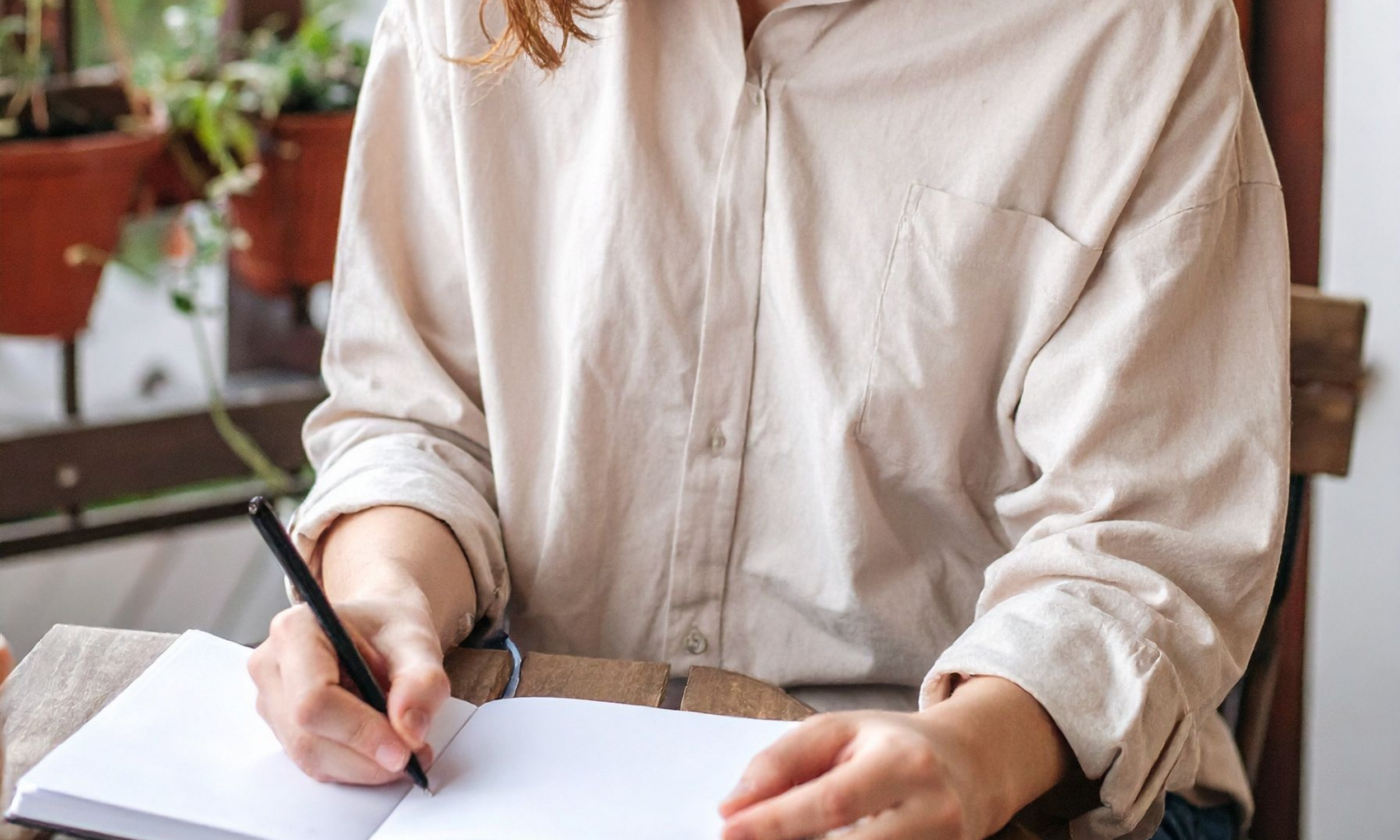 Woman sitting at a table journaling.
