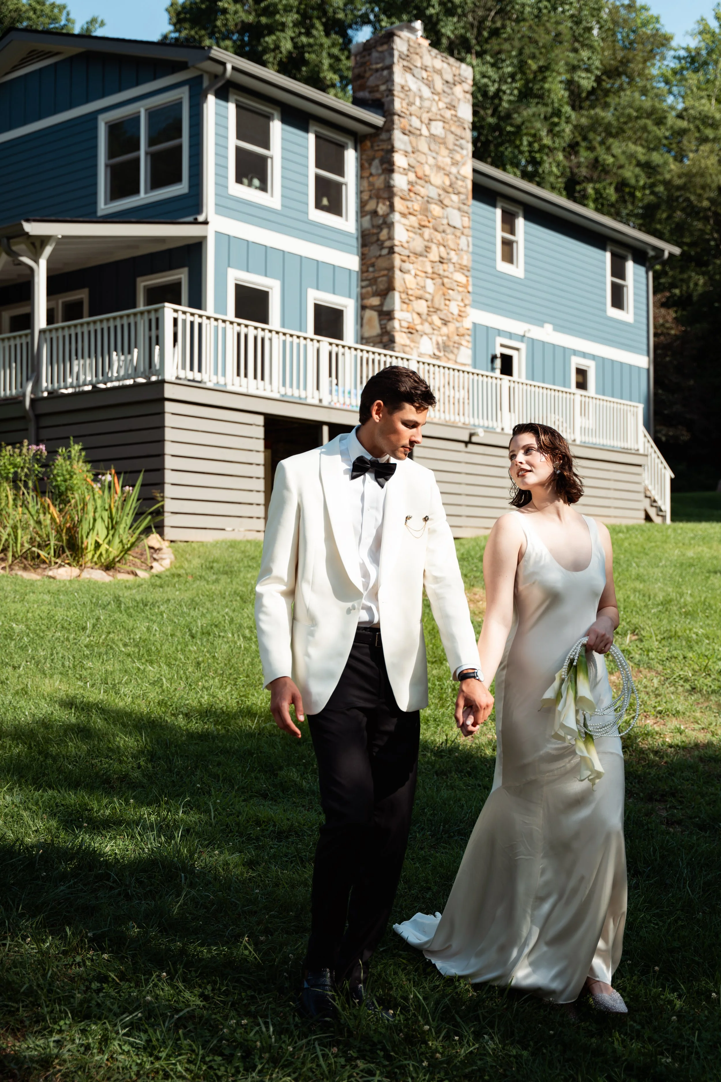 Couple outside the blue house at Caya Azul, an intimate Asheville wedding weekend venue in the North Carolina mountains.