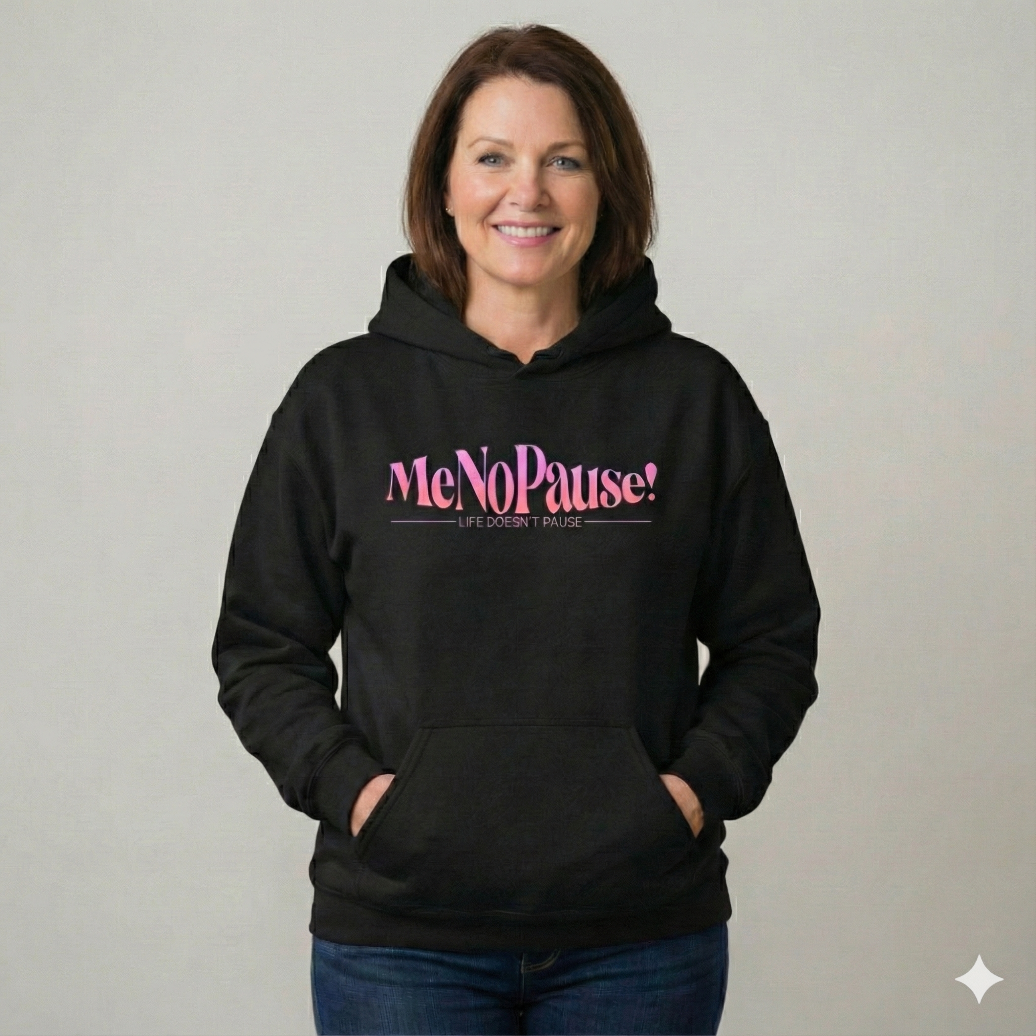 Woman wearing black unisex MeNoPause!™ Empowerment Hoodie with centered pink logo.