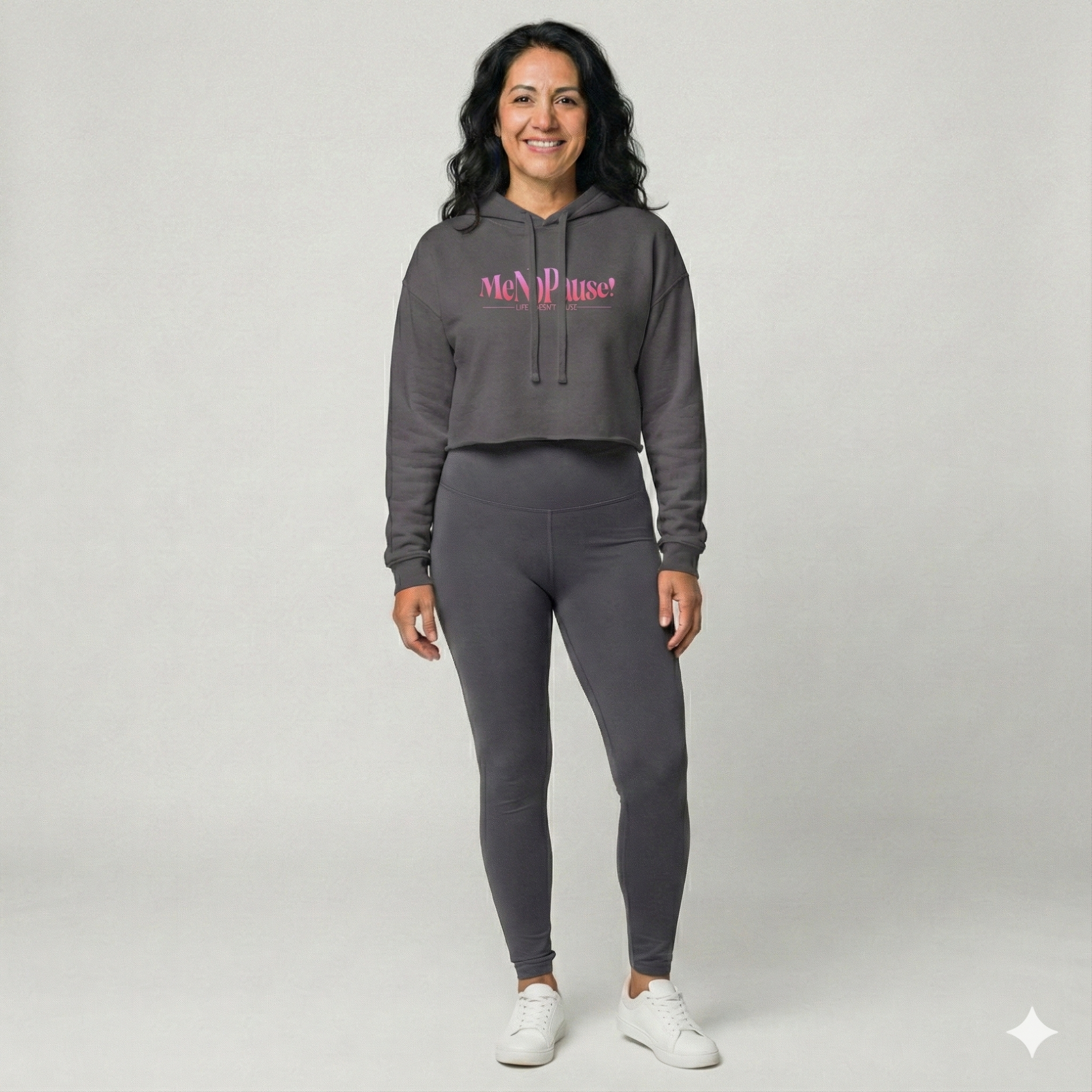 Woman wearing storm grey cropped MeNoPause!™ hoodie with pink logo and raw hem.
