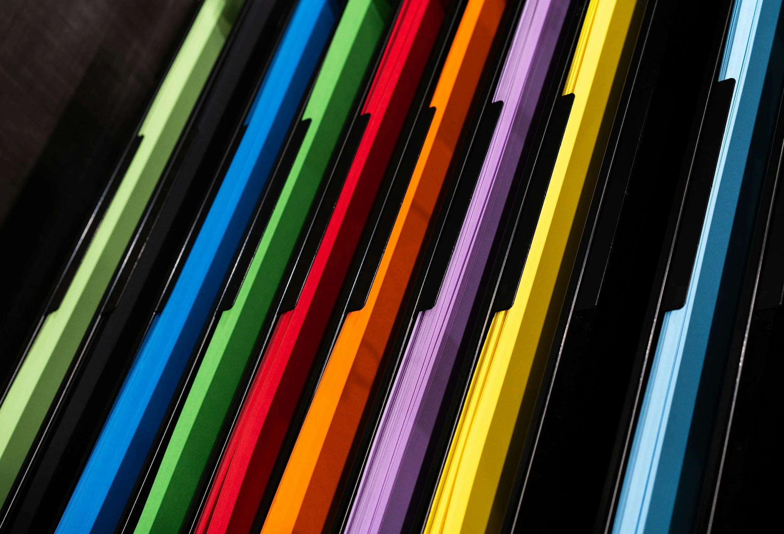 Close-up of colorful piano keys in rainbow order from left to right.