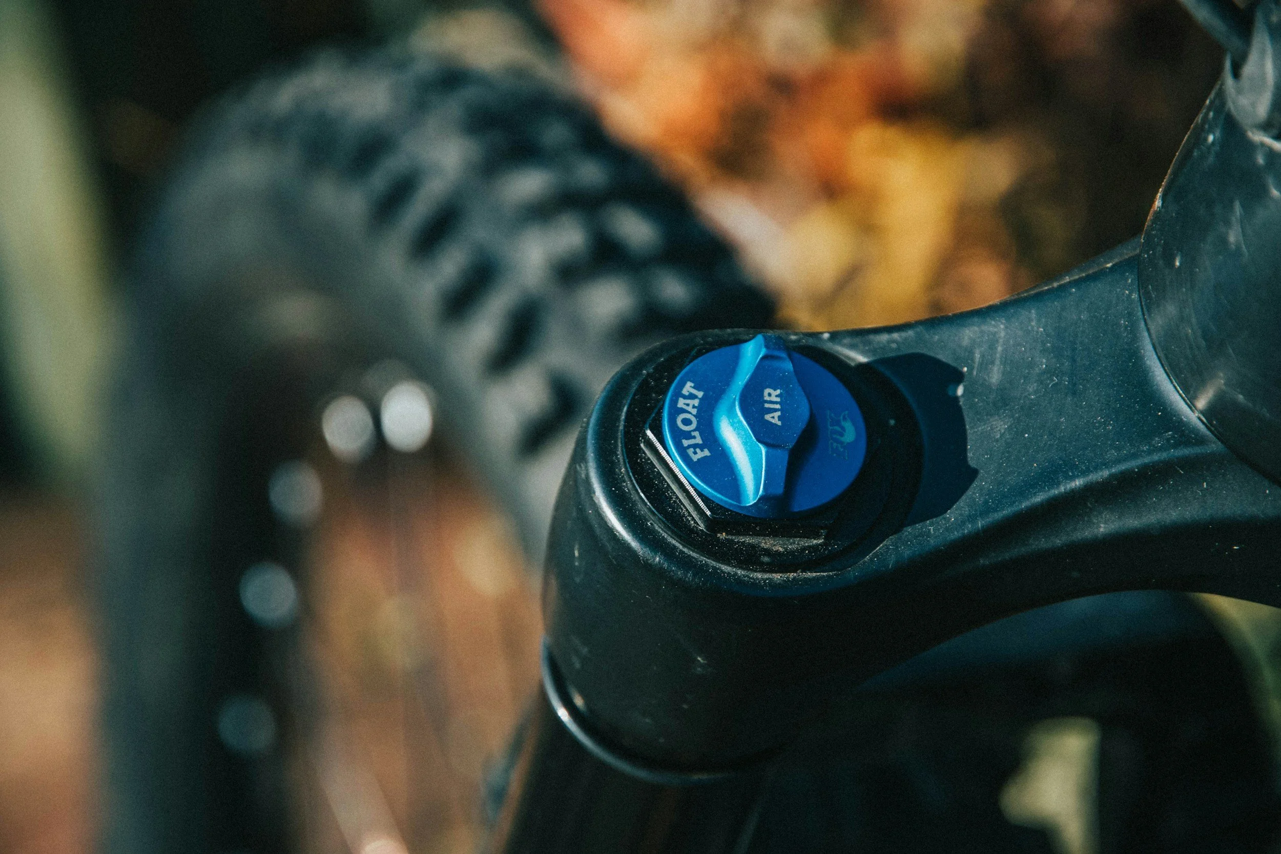 Vérin de suspension d'un vélo avec un levier bleu marqué 'FLOAT AIR'. Fourche, suspension, air shaft, coid