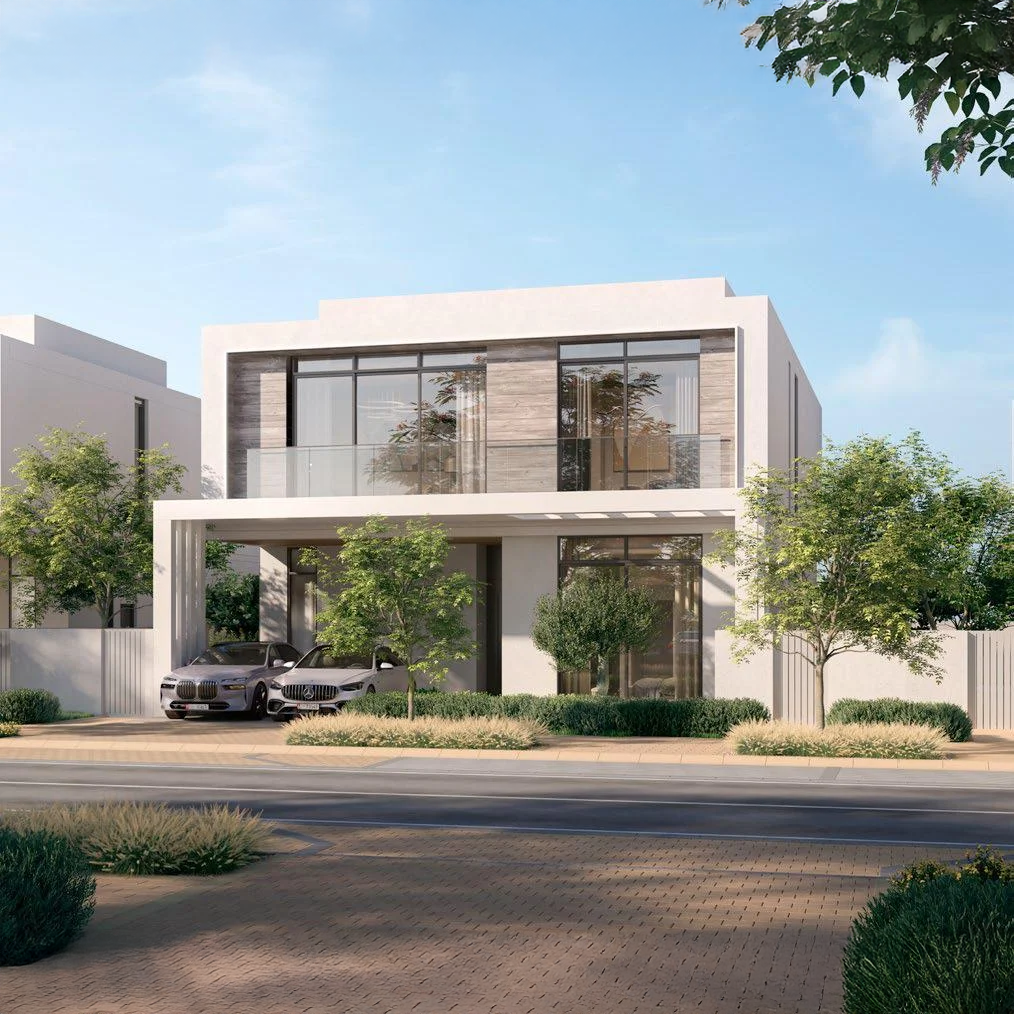 Modern two-story house with large glass windows, a balcony, surrounded by trees, with cars parked in the driveway.