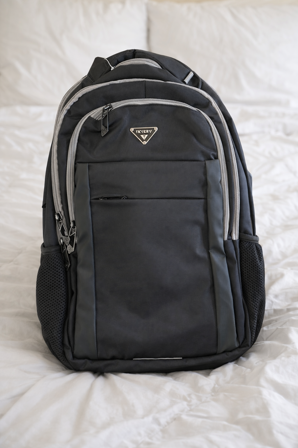 bsckpack on bed with white comforter