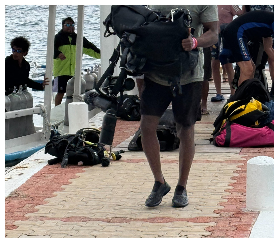Diver walking on a dock wearing CROSSKIX water shoes after a day of diving..