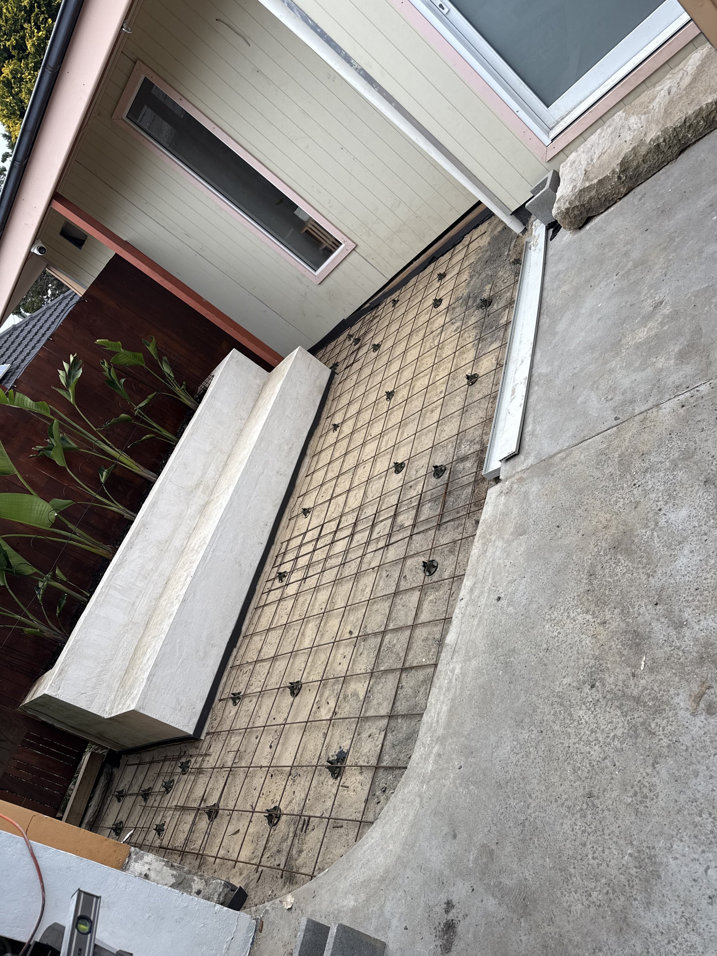 A concrete patio area under construction with reinforcement mesh laid out