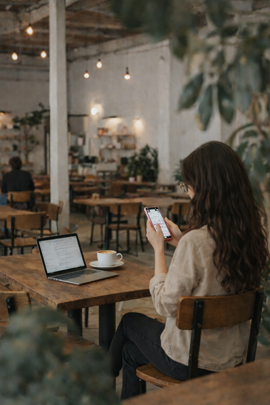 Woman working on social media content and digital marketing from a laptop and smartphone.