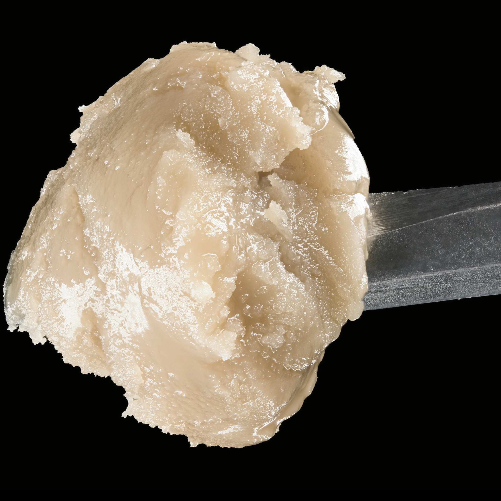 Close-up of a scoop of vanilla ice cream on a silver spoon against a black background.