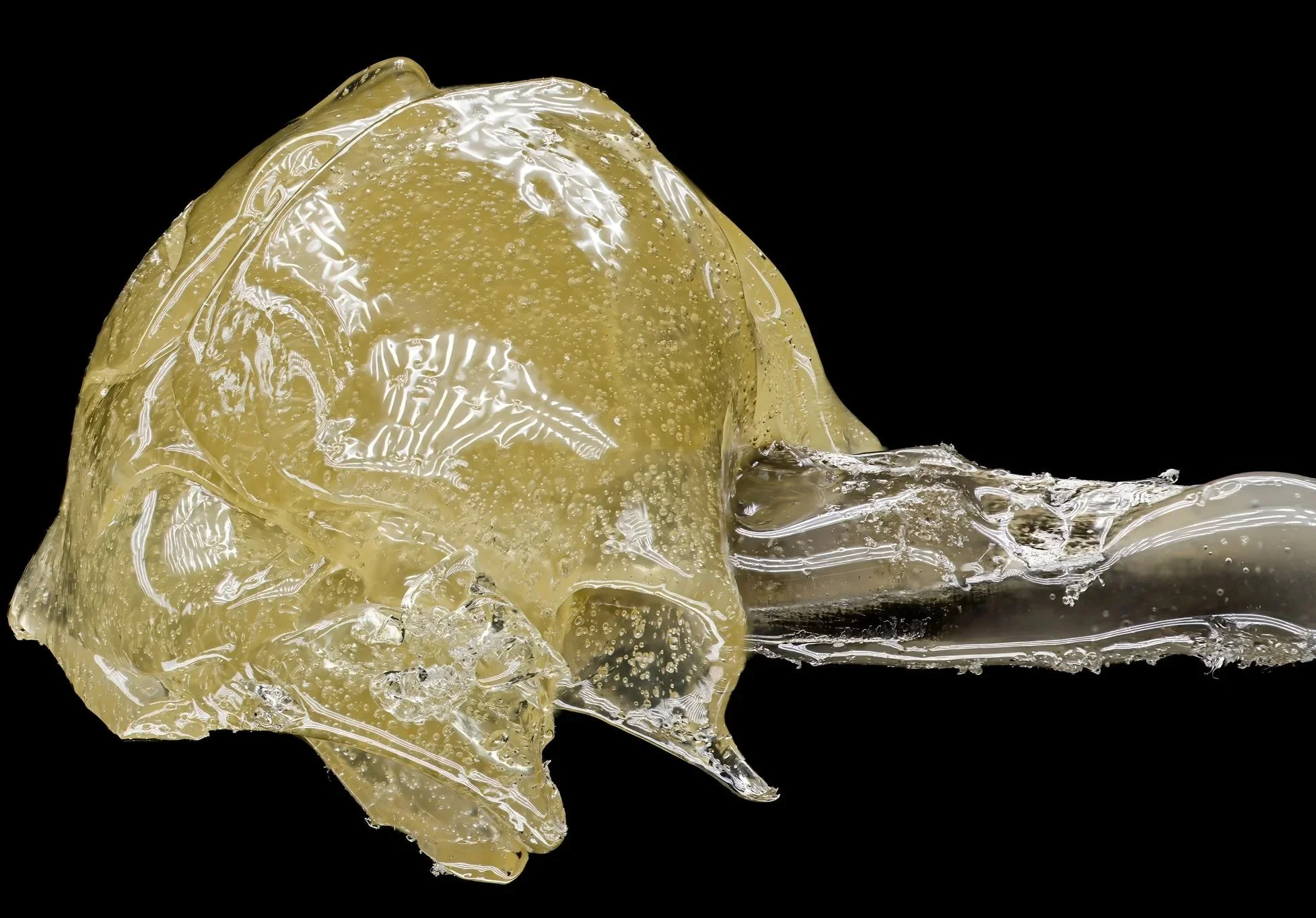 Close-up of a melted yellowish chewing gum on a black background.