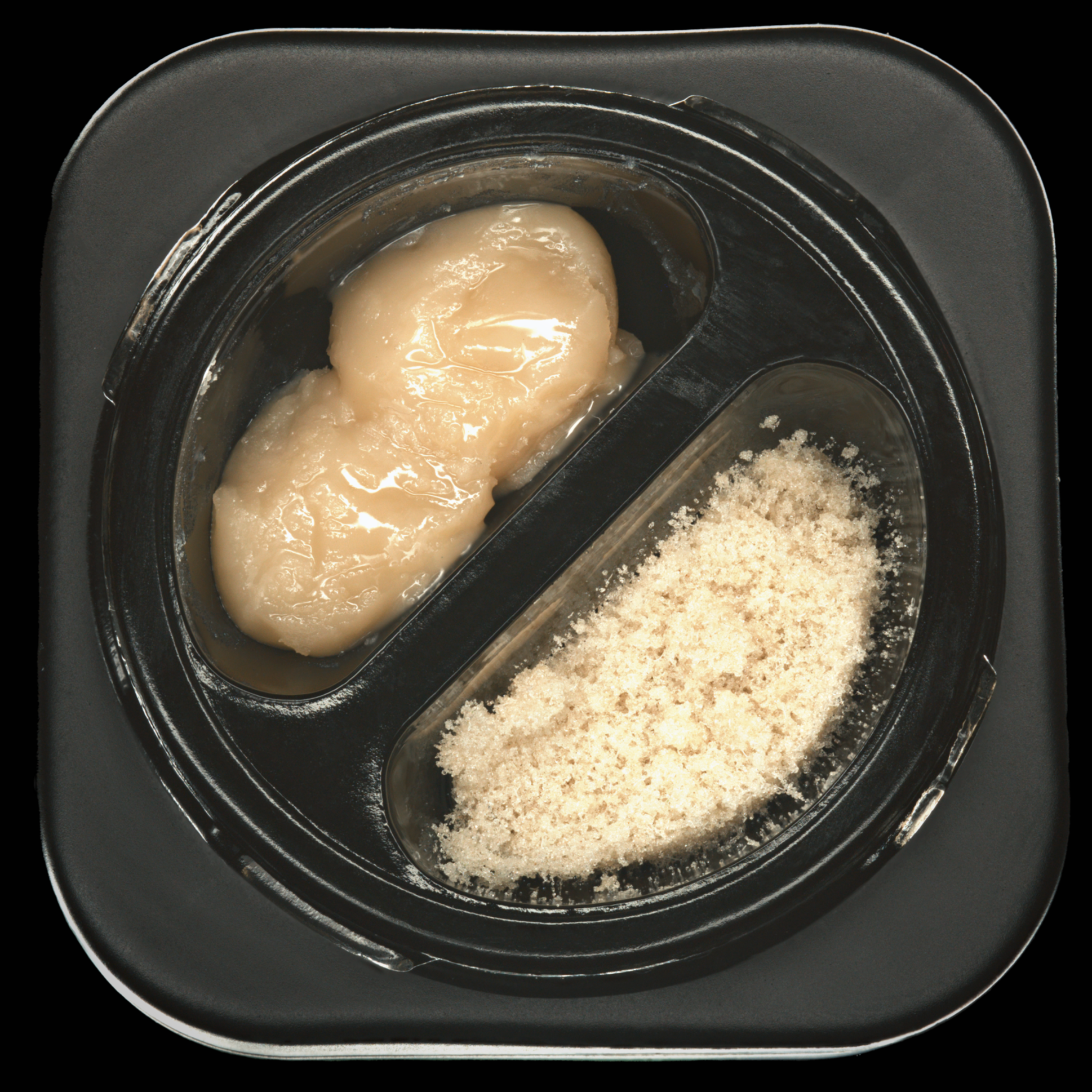 A black divided tray containing a scoop of mashed turnip and a serving of grated cheese.