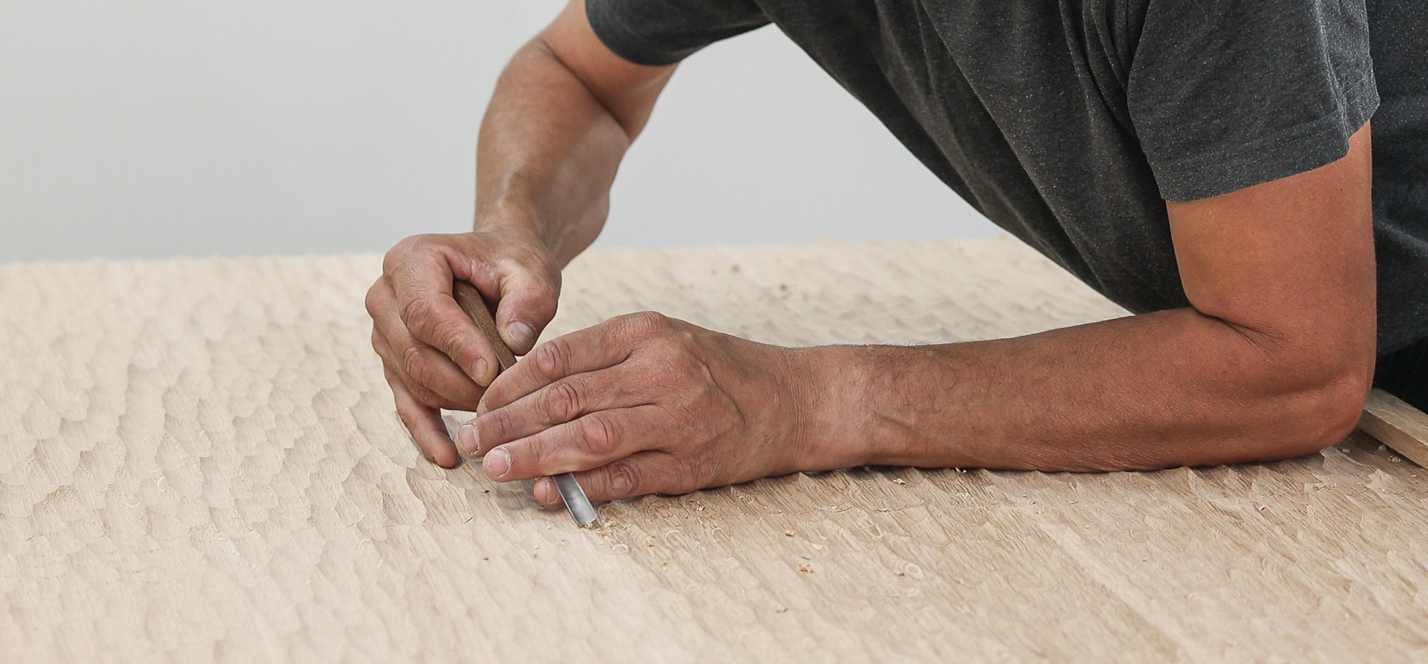ébéniste agenceur sculptant à la gouge panneau de bois chez Lamellux