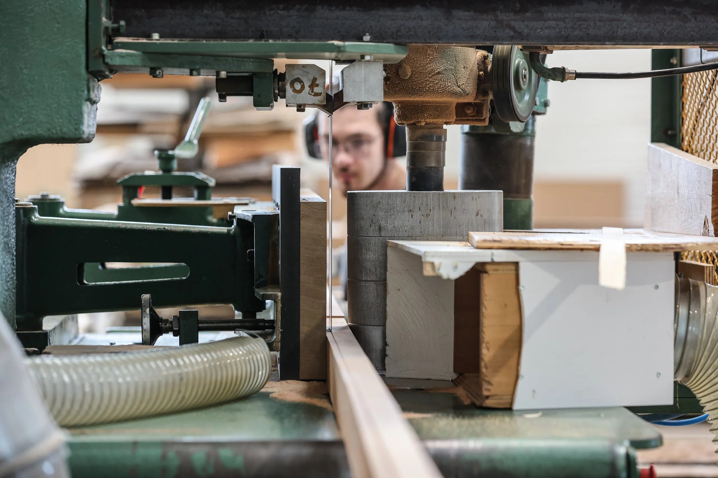 Artisan ébéniste agenceur Lamellux sciant du bois massif pour réaliser des placages sciés.