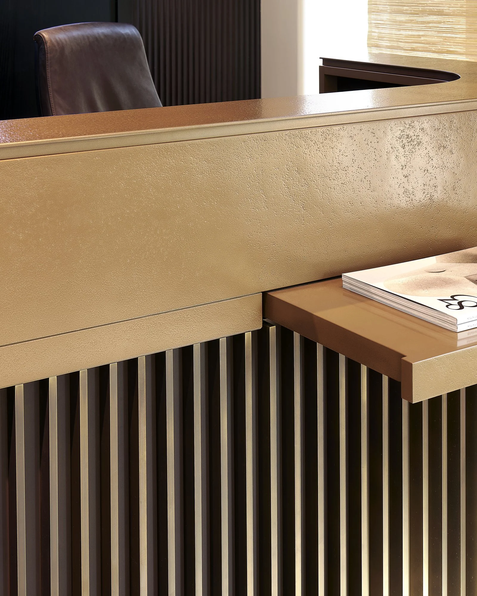 détail d'une banque d'accueil en laiton. Fabrication par l'agenceur ébéniste Lamellux