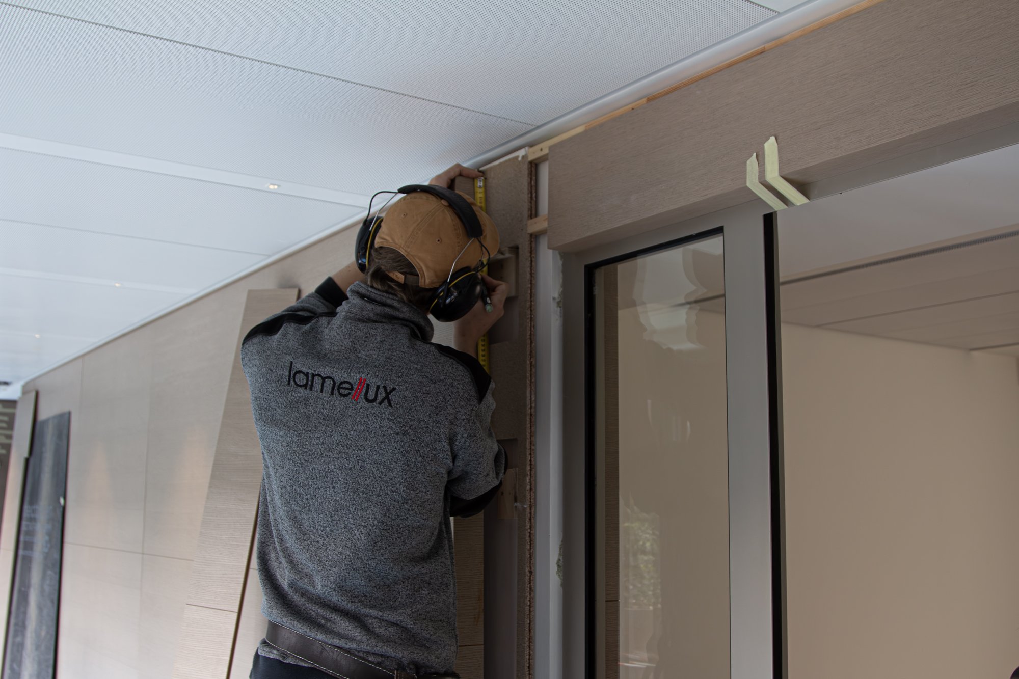 ébéniste agenceur installant des habillages muraux sur un chantier Lamellux