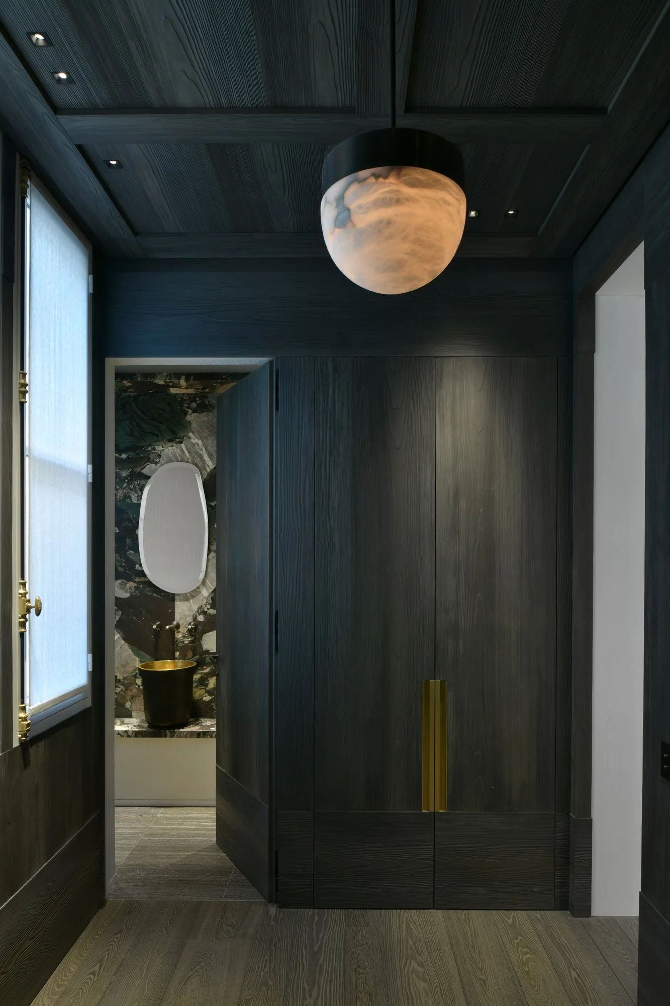 Agencement de mur et de plafond en épicéa brossé et patiné sombre. poignée sur mesure en laiton. réalisation par l'ébéniste agenceur Lamellux