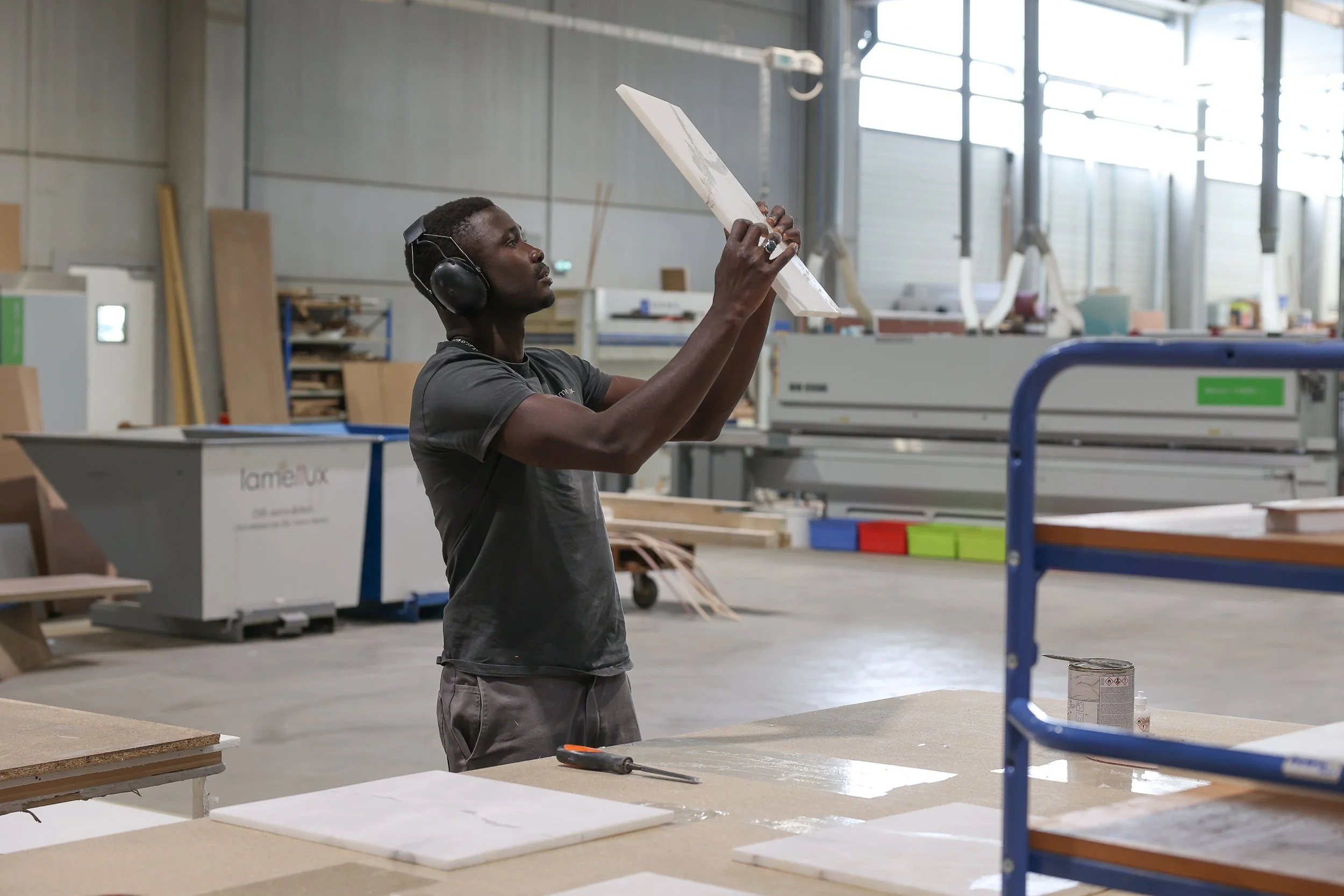 ébéniste agenceur manipule une plaque d'albâtre dans l'atelier Lamellux