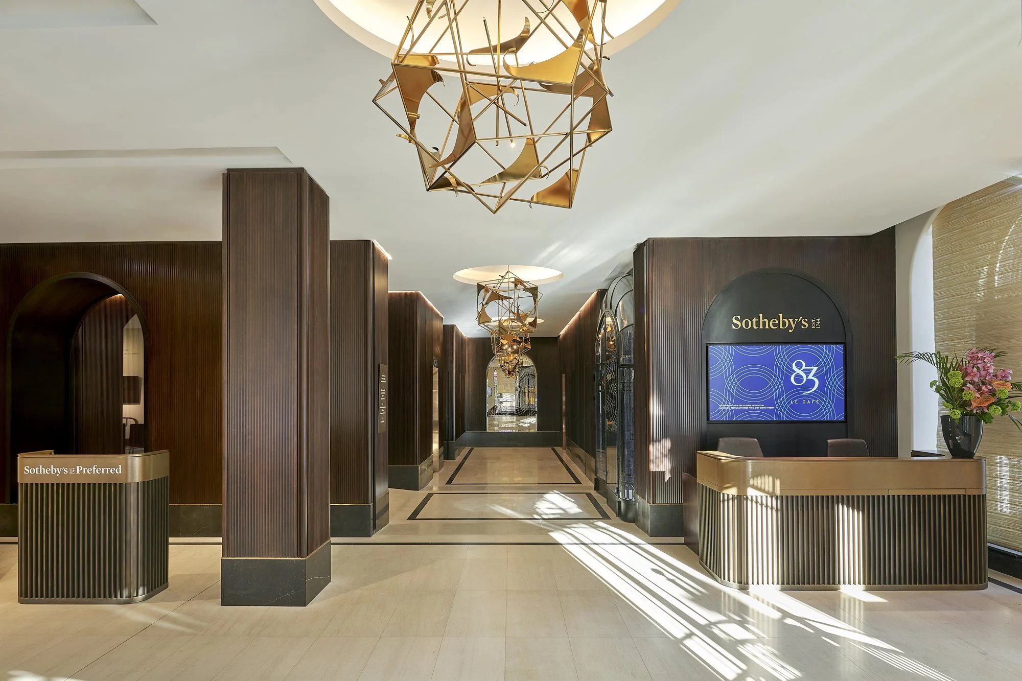 Agencement du hall d'accueil avec boiserie sur mesure et banques d'accueil en laiton. Fabrication par l'agenceur ébéniste Lamellux