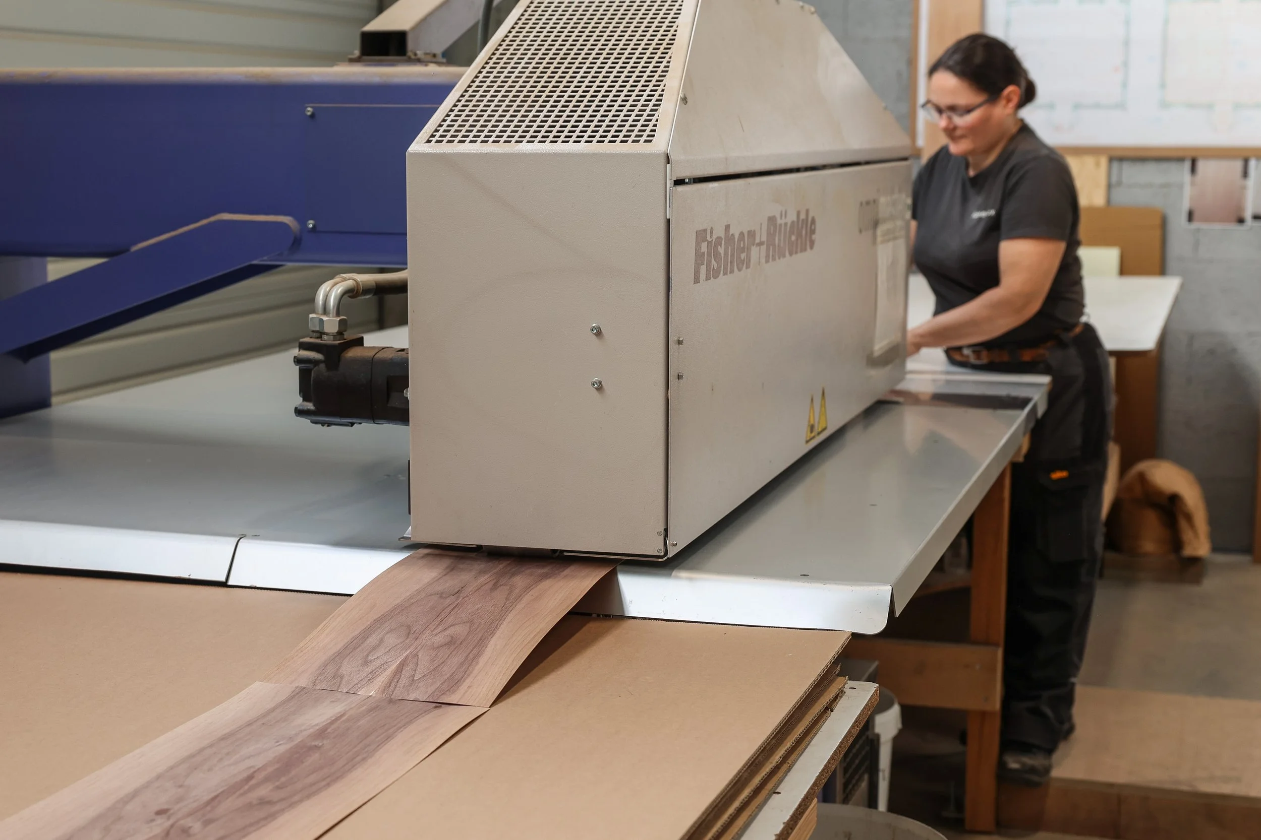 Femme ébéniste agenceur chez Lamellux réalisant le jointage du placage