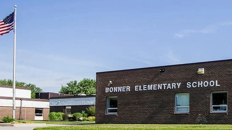 Front view of Bonner Elementary School building with a flagpole flying the American flag nearby.