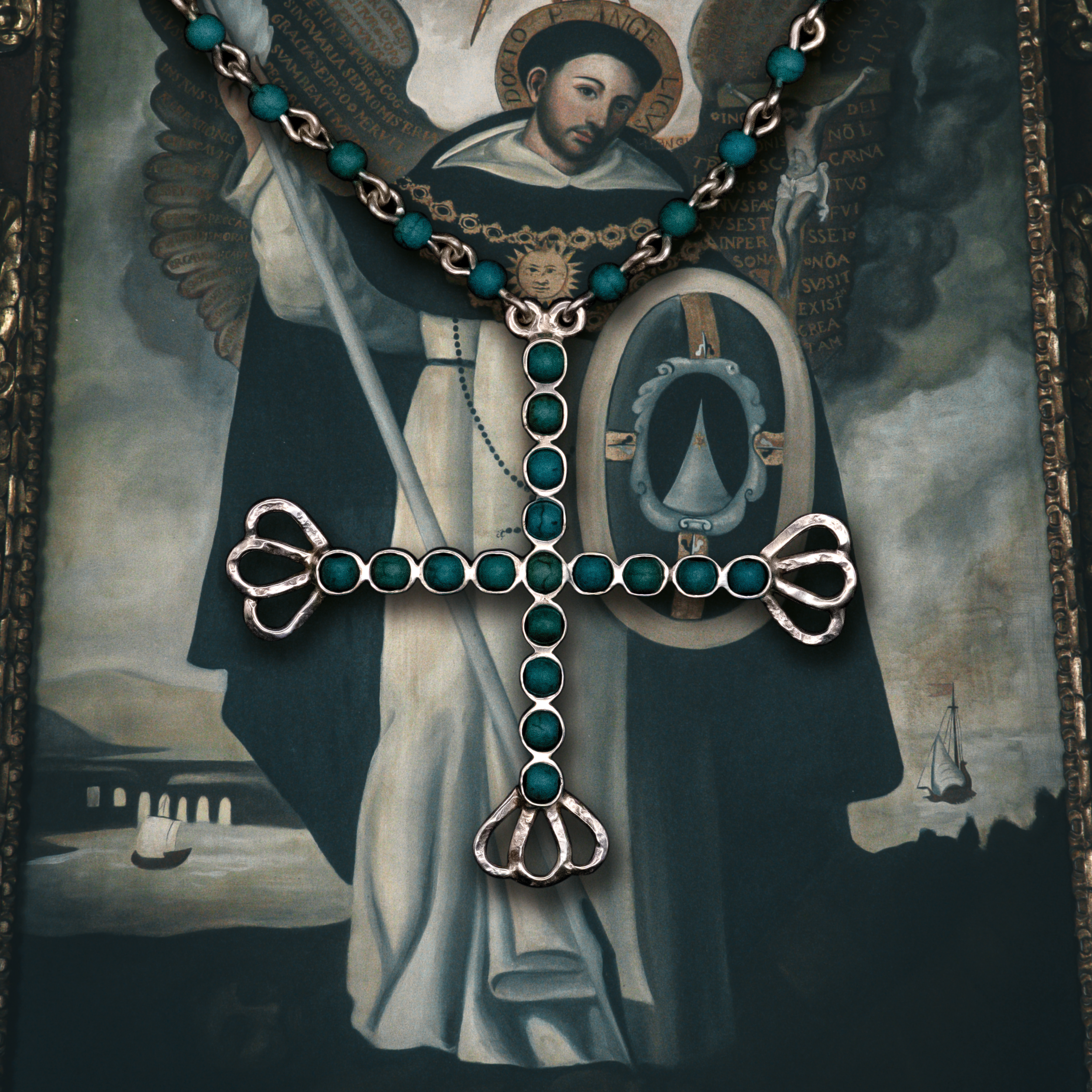A silver and turquoise beaded cross necklace placed over a religious painting of a saint holding a banner and a staff, with ships and a bridge in the background.
