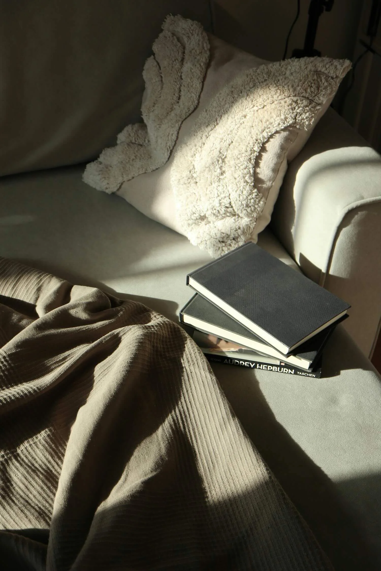 Open notebook and pen resting on a blanket beside a cup of tea, evoking comfort and reflection.
