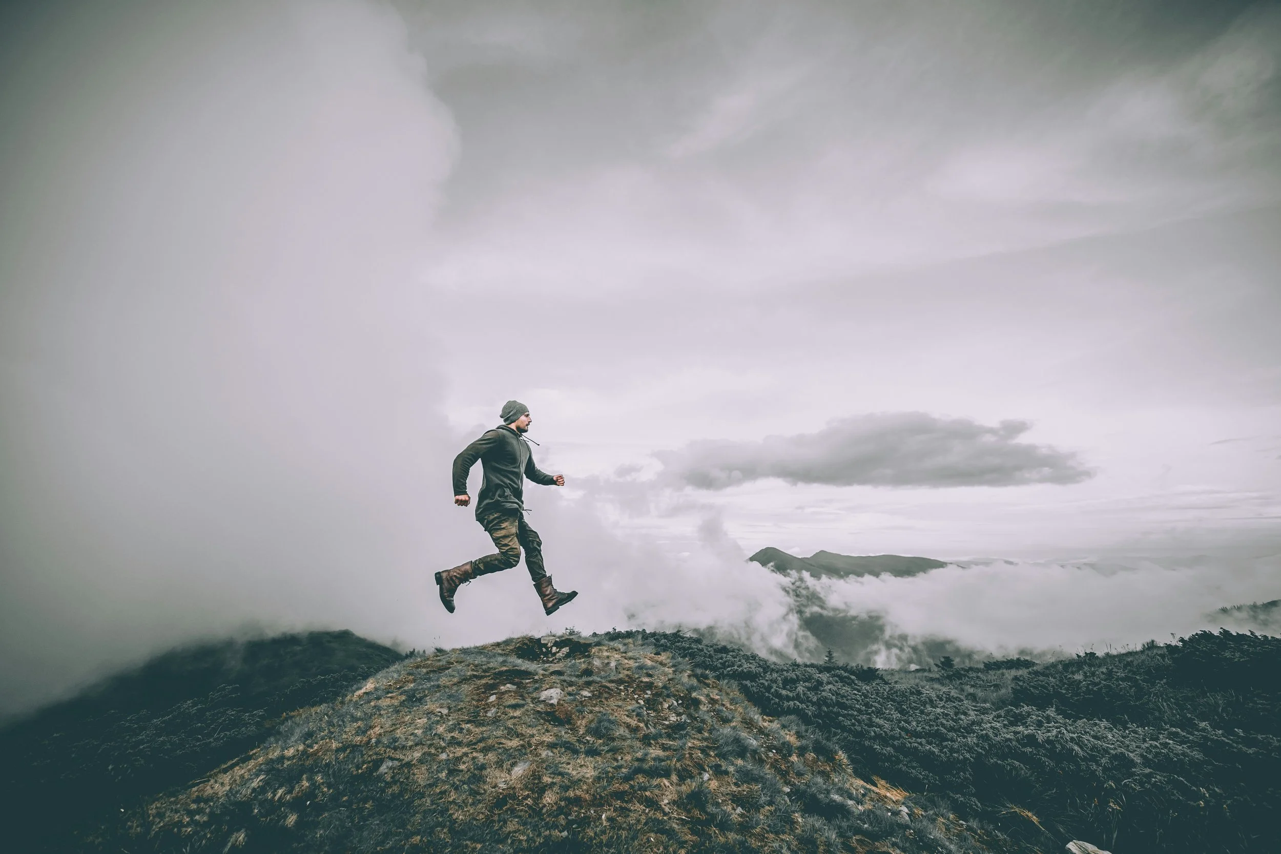 happy man skipping on a mountain