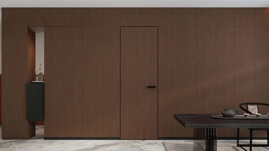 Interior wall with wooden paneling, a closed door, and a dining table with a teapot and cups in a modern styled room.