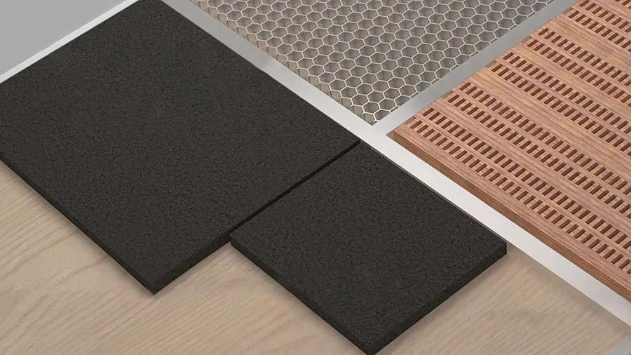 Close-up of various flooring samples including black rubber tiles, a metallic honeycomb grid, and a wooden slat pattern.