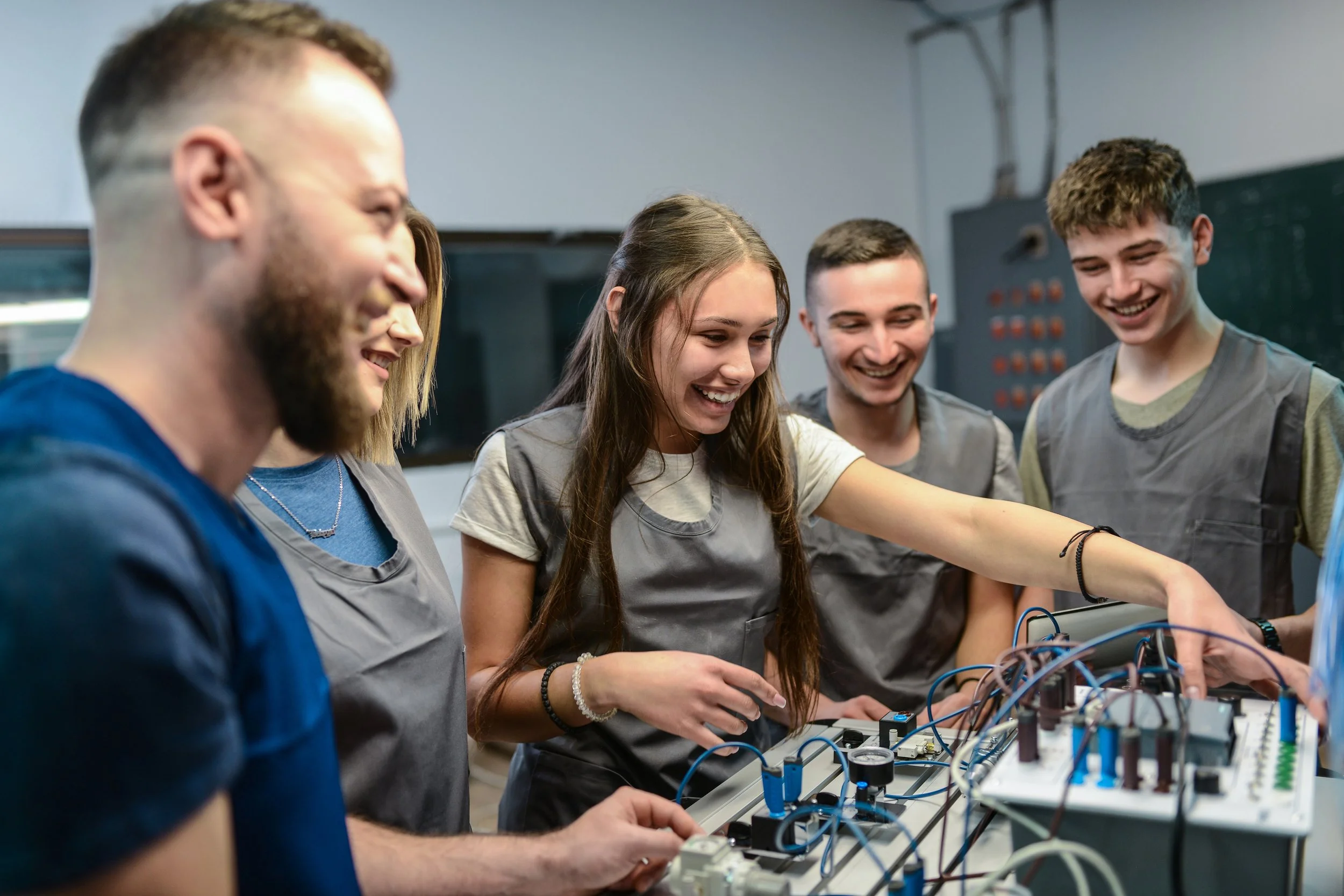 Young people working together on an engineering project in a workshop environment.