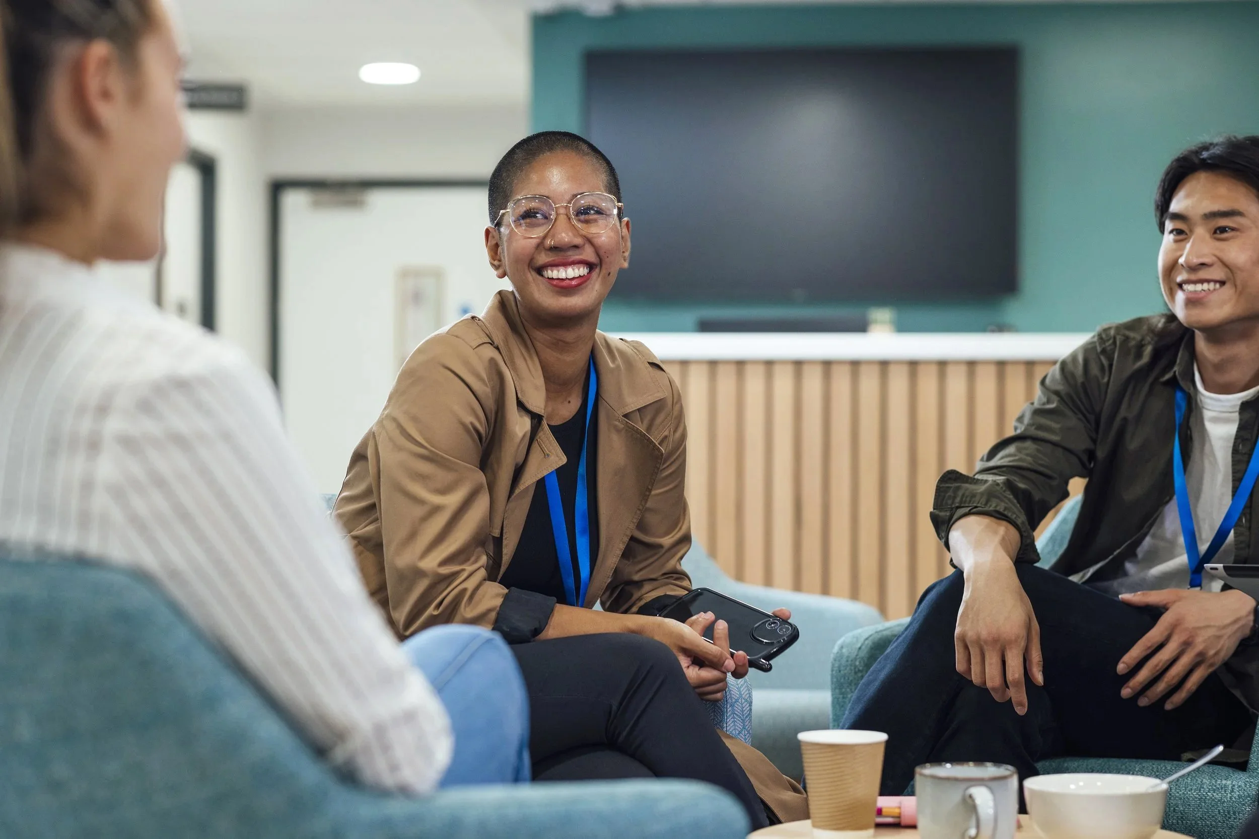 Smiling engineer sitting in a collaborative workspace during a team discussion.