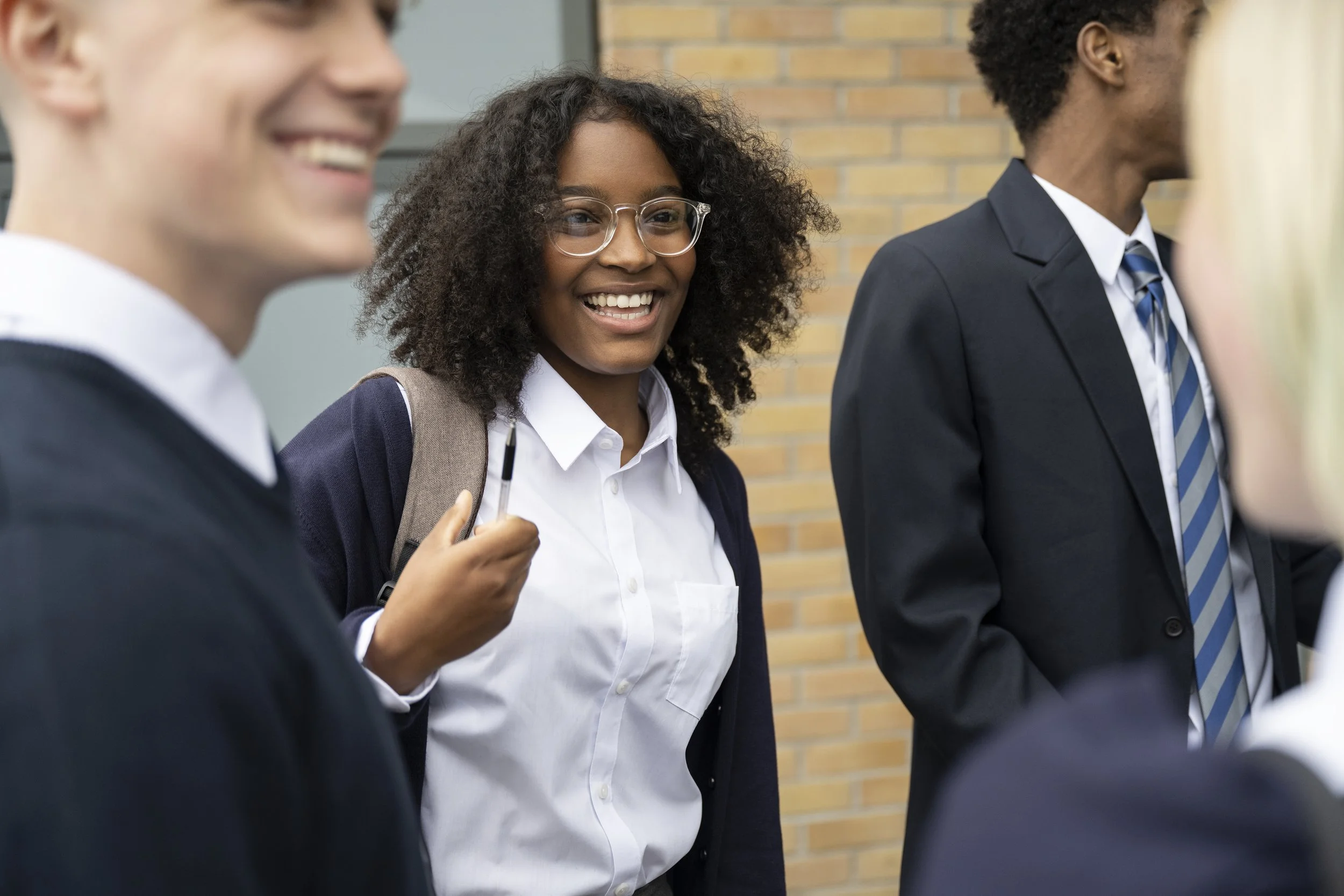 Young people talking together outside a school or college building.