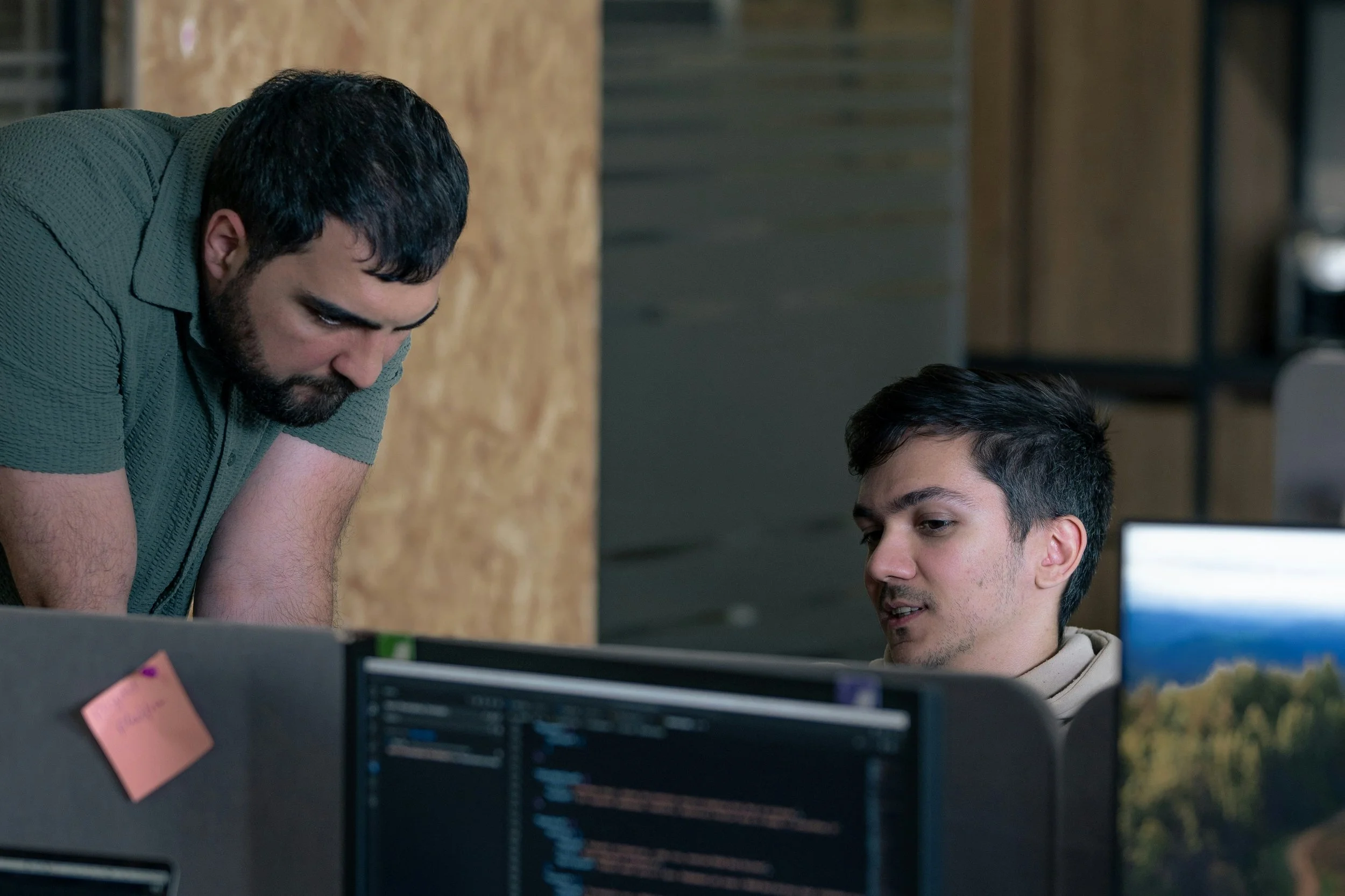 Engineering team reviewing work on computer screens.