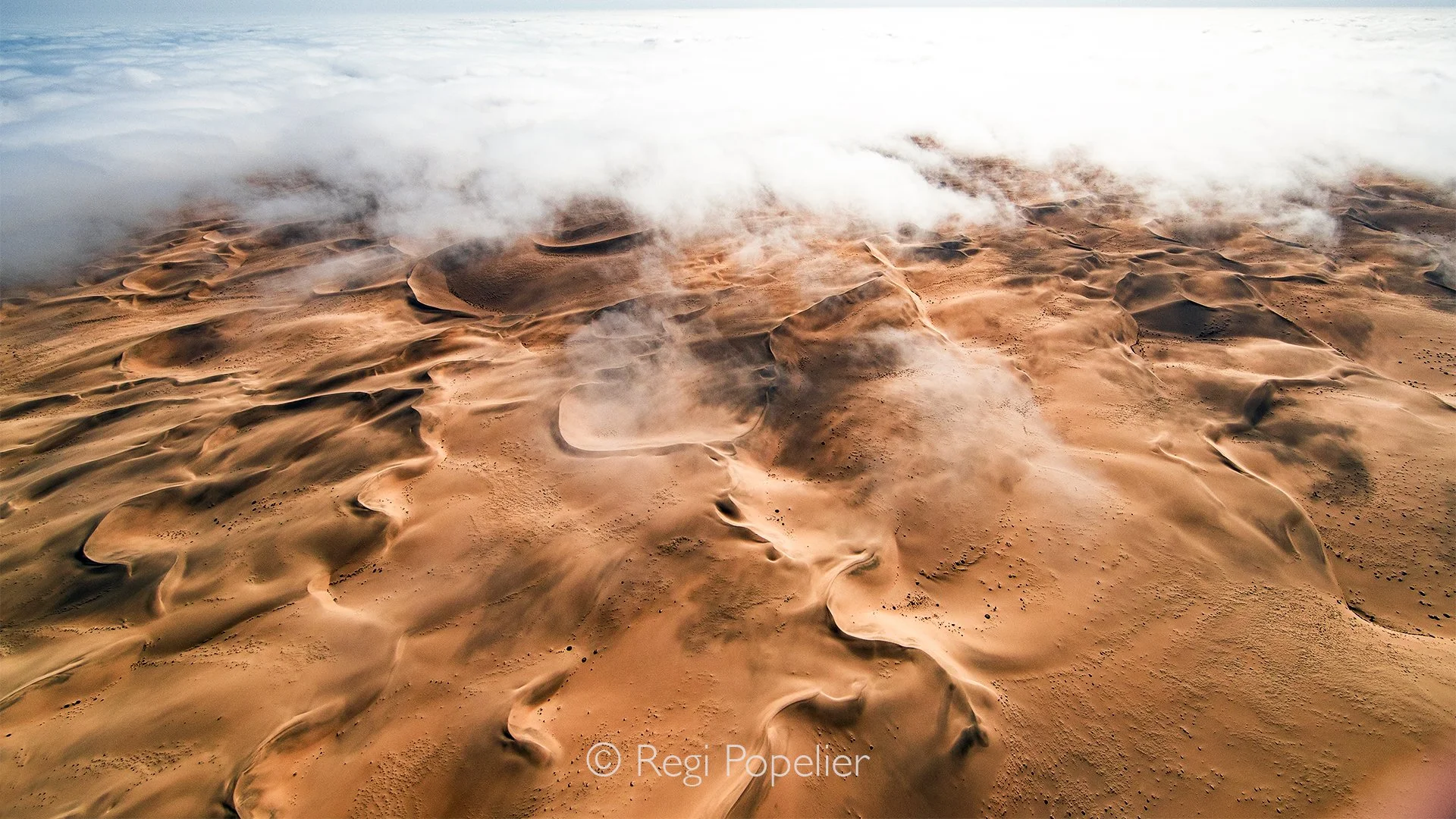 Namibia100 - Looking out as we flew through the morning clouds reveals the unique atmospheric boundary layer of the Namib. The interaction between the cold Atlantic air and the intense heat radiating from the massive sand structures creates a turbule