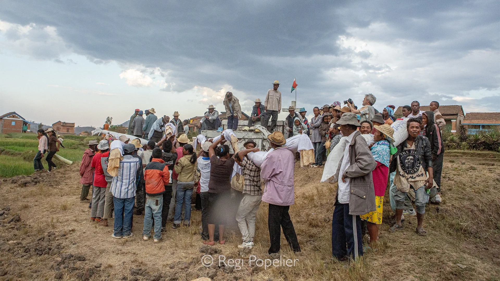MADA057 -  Famadihana: Turning of the Bones. Families exhume the remains of their ancestors to wrap them in fresh silk shrouds and dance with them, celebrating life and eternal connection. Photographing with Pierrot Men 