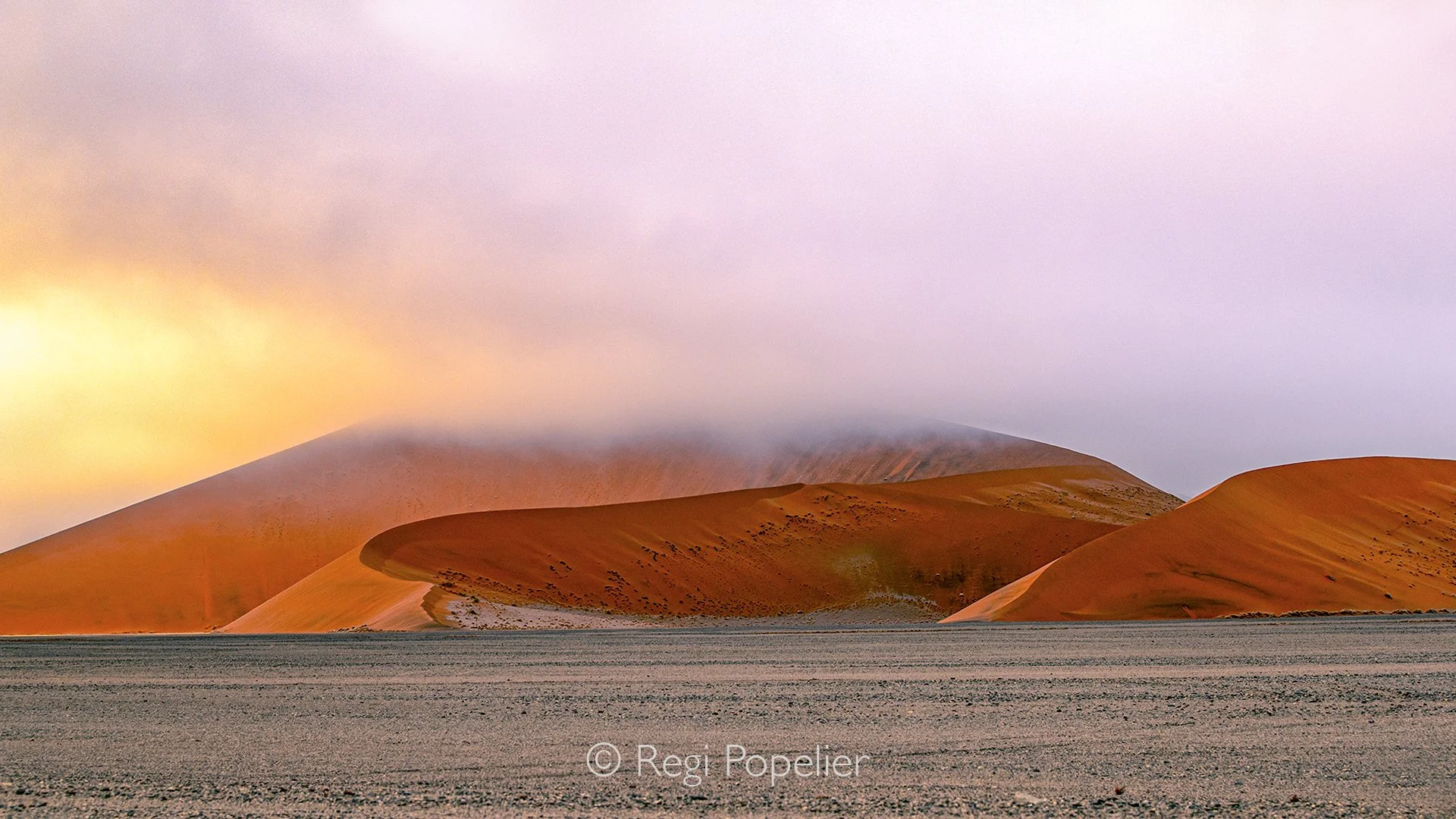 Namibia062 - The lifeline of the Namib. Capturing this low lying morning fog while on the road to Deadvlei documents the desert’s most crucial weather event. This advection fog forms when warm, moist air from the Atlantic Ocean meets the icy Benguela