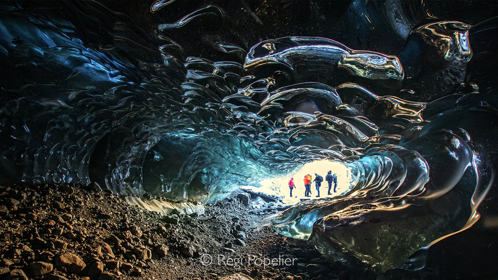 ICEL045 - Visitors at  the Crystal Ice Cave in Iceland.
