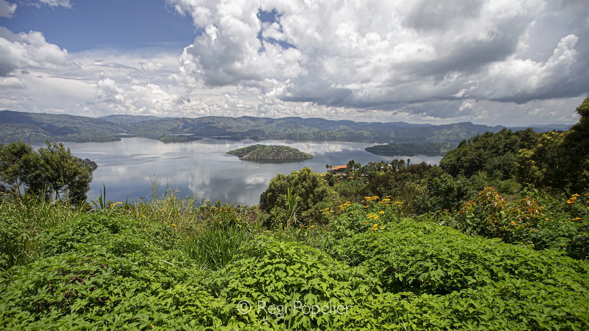 RWANDA035 - Every morning begins with an ever changing masterpiece. Clouds roll across the Virunga Mountains, casting shifting light and shadows over the endless green hills that surround Rwanda's ancient volcanoes.