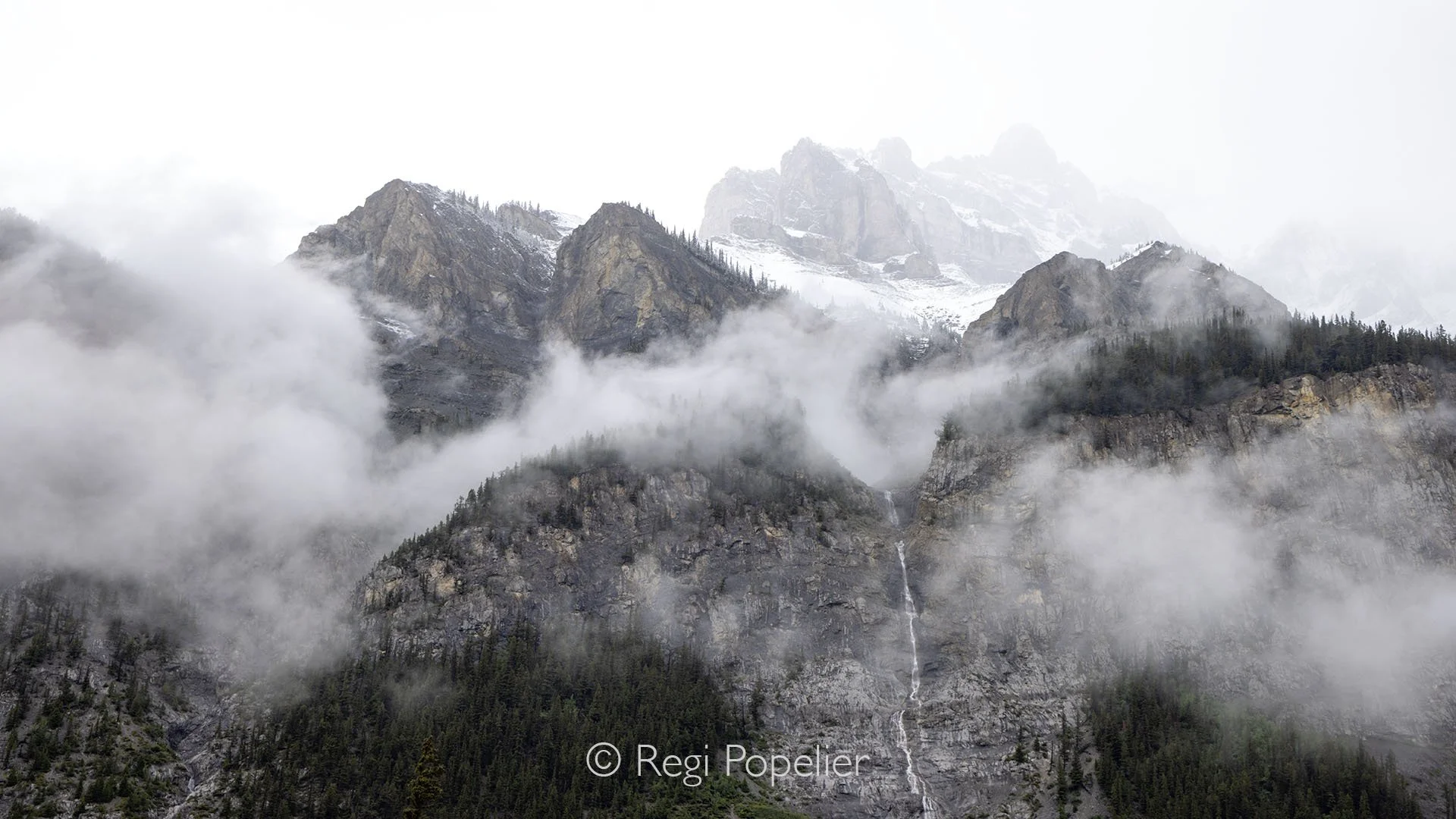 CAN012 - The rock formation emerges from the fog, mysterious and ethereal against the soft gray haze.