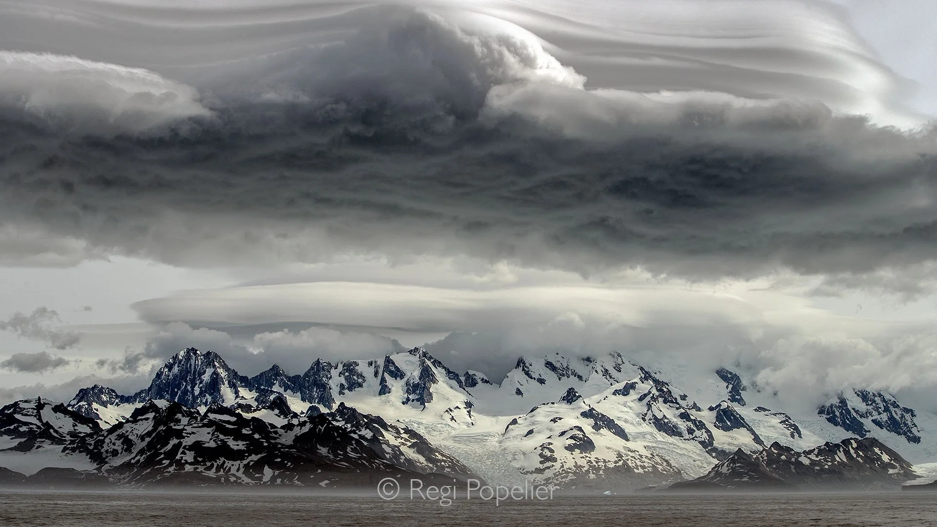 ANT008 - Dramatic coastline of South Georgia,  snow capped mountains surrounded by mighty cloud fields, a true spectacle of the sub-Antarctic.