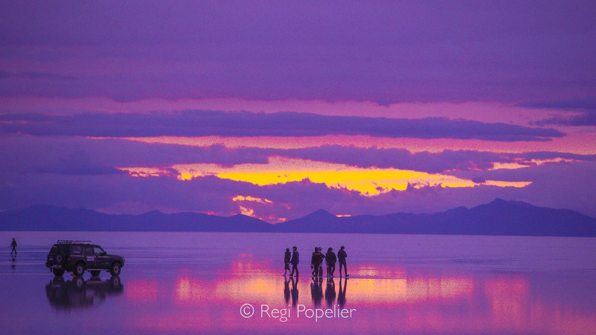 BOL018 - Salar de Uyuni at evening, with a thin layer of water reflecting dramatic blue and red skies, Bolivia’s salt flats at their most magical.