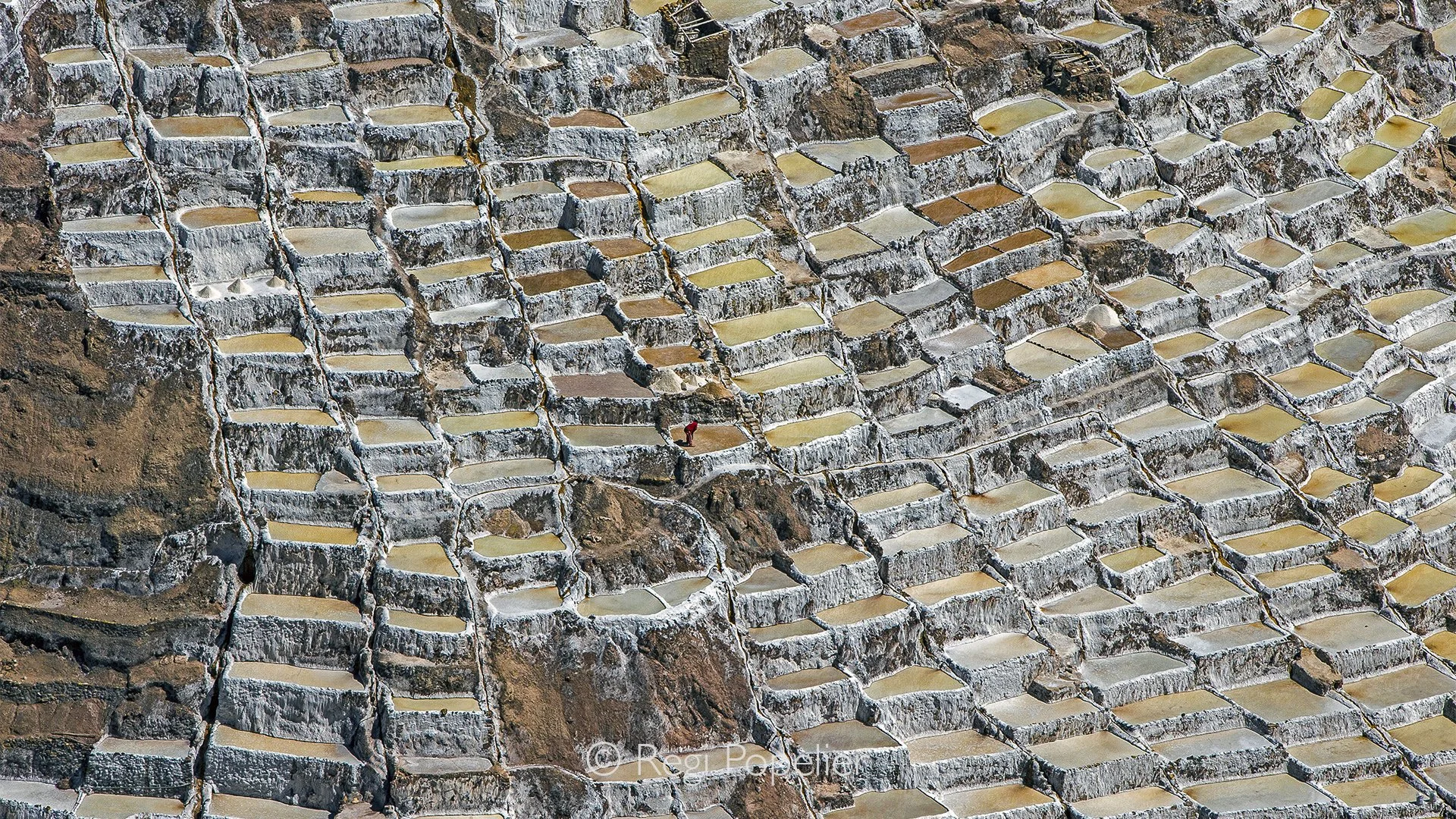 PERU028 - Across Peru’s coastal landscapes, traditional salt harvesting reveals a timeless relationship between people, land and the elements. In open salt pans, workers collect the crystallized minerals left behind by the evaporation of seawater, cr