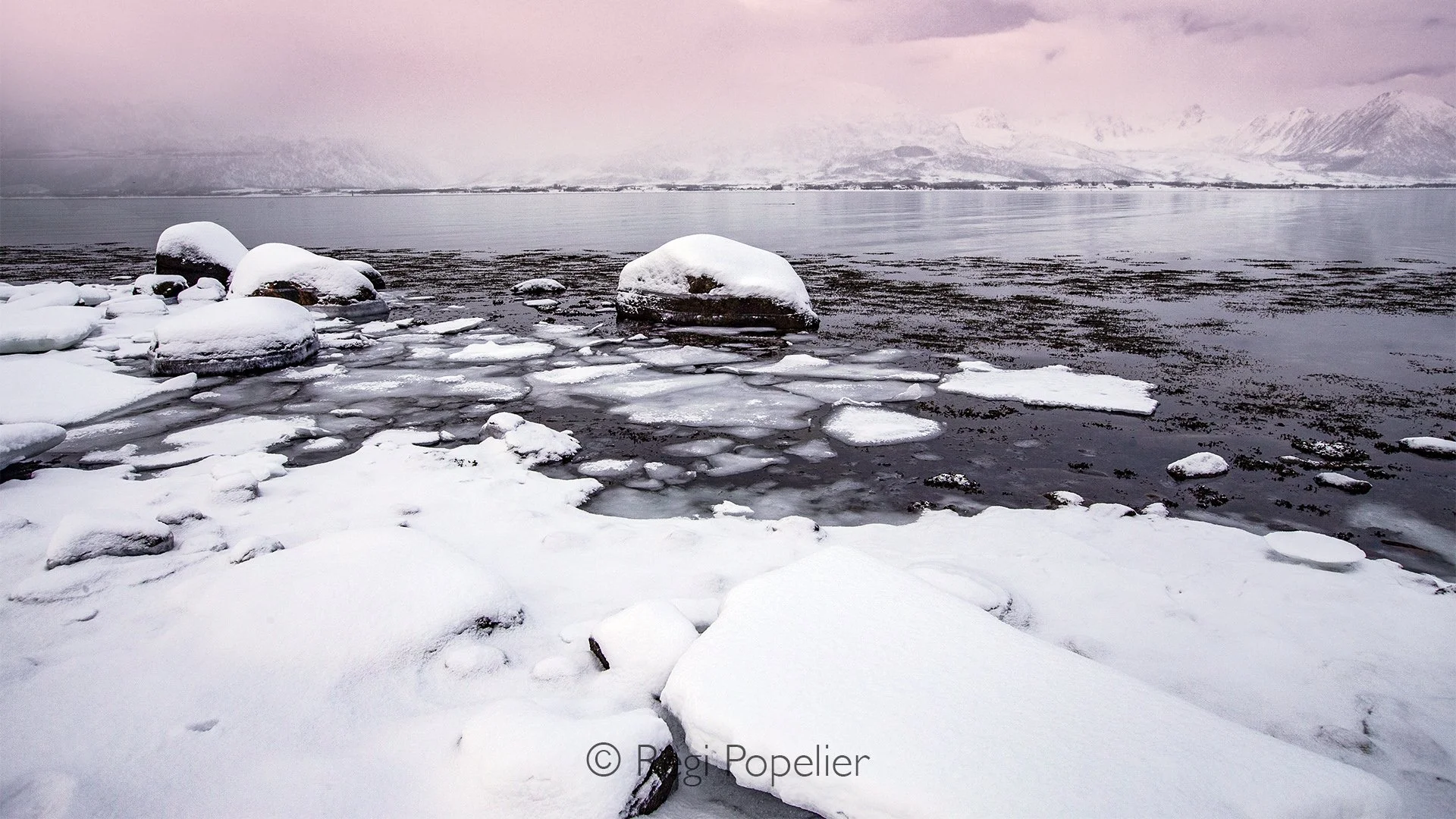 NORWAY019 - Snow covered rocks stand like silent guardians, their graceful forms softened by winter's embrace.