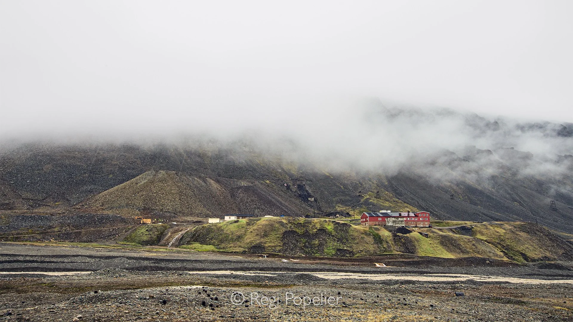 NPOLE003 - Green tundra, dark rocks, and fog on the peak, and the presence of humans  form a remarkable Arctic palette.