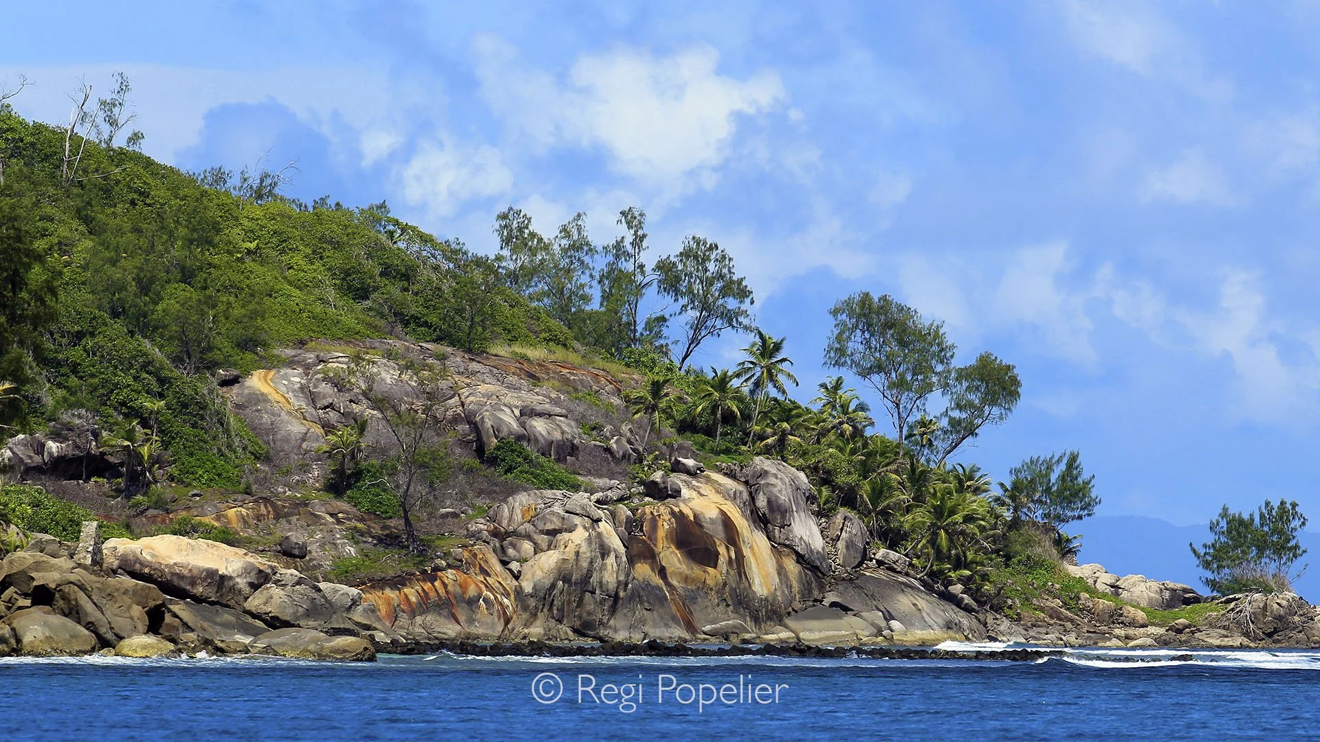 Seychelles001  - Along the Seychelles coastline, sculpted granite rocks meet turquoise waters in a timeless display of nature’s artistry.