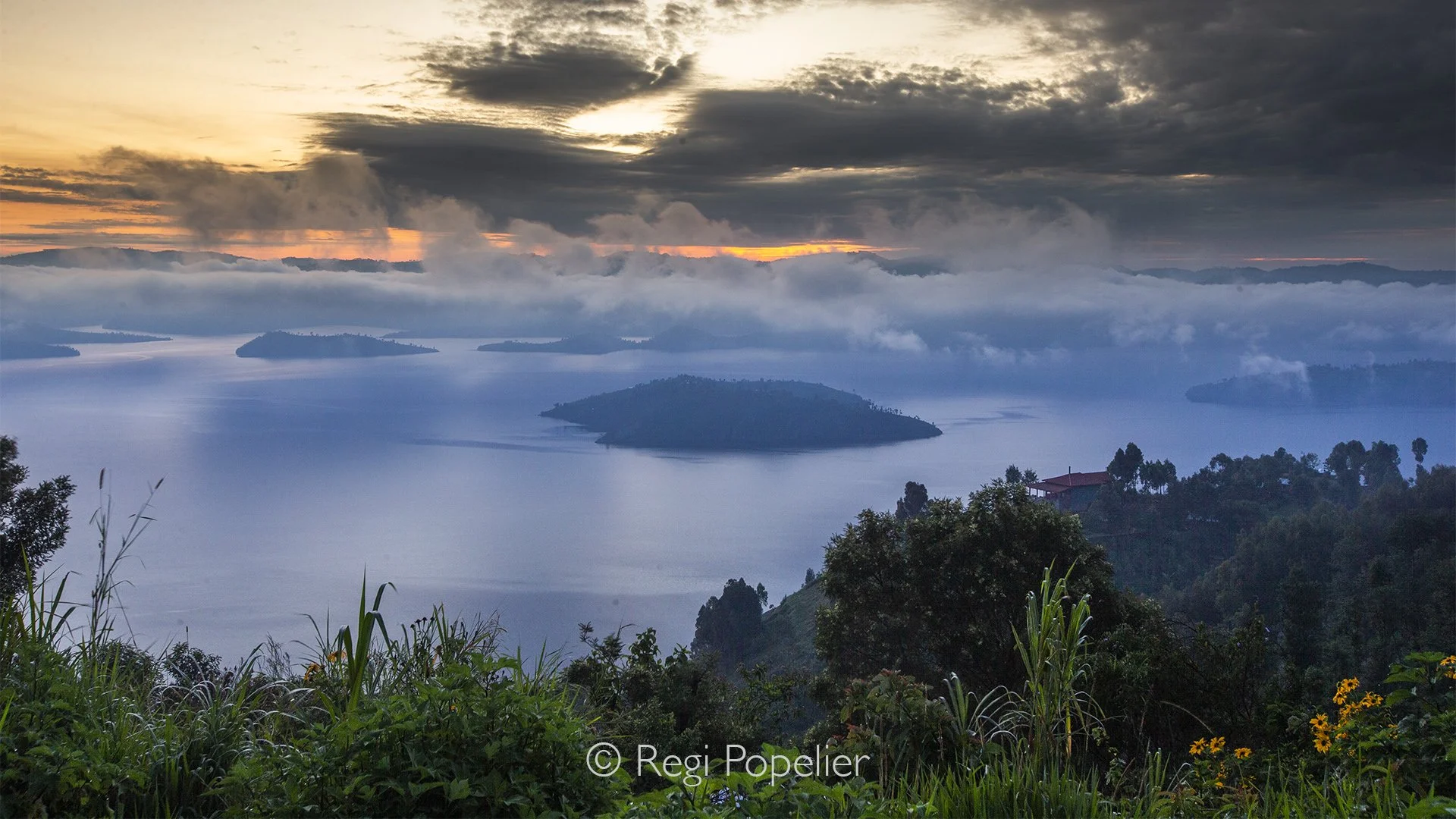 RWANDA033  - As the sun rises above the horizon, golden light washes over the Virunga range. The peaceful silence, broken only by distant bird calls, creates a scene of remarkable serenity.