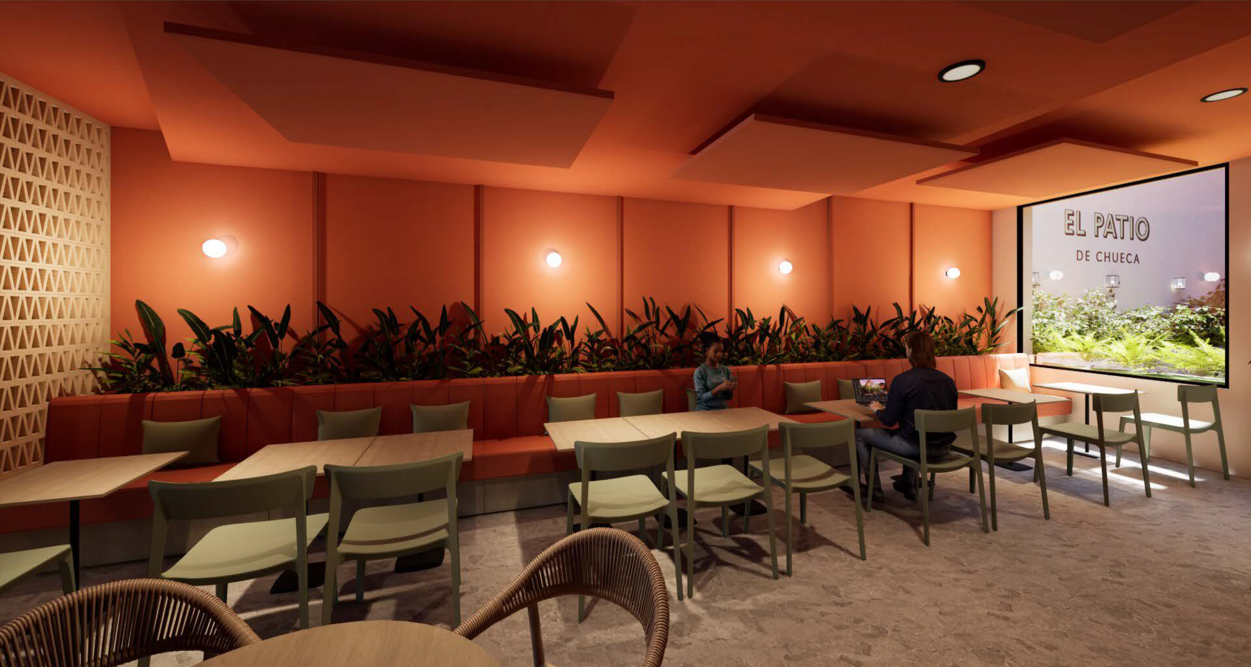 Interior de un restaurante con paredes color coral y sillas verdes, una pared con plantas y una pantalla que dice 'El Patio de Chueca'.